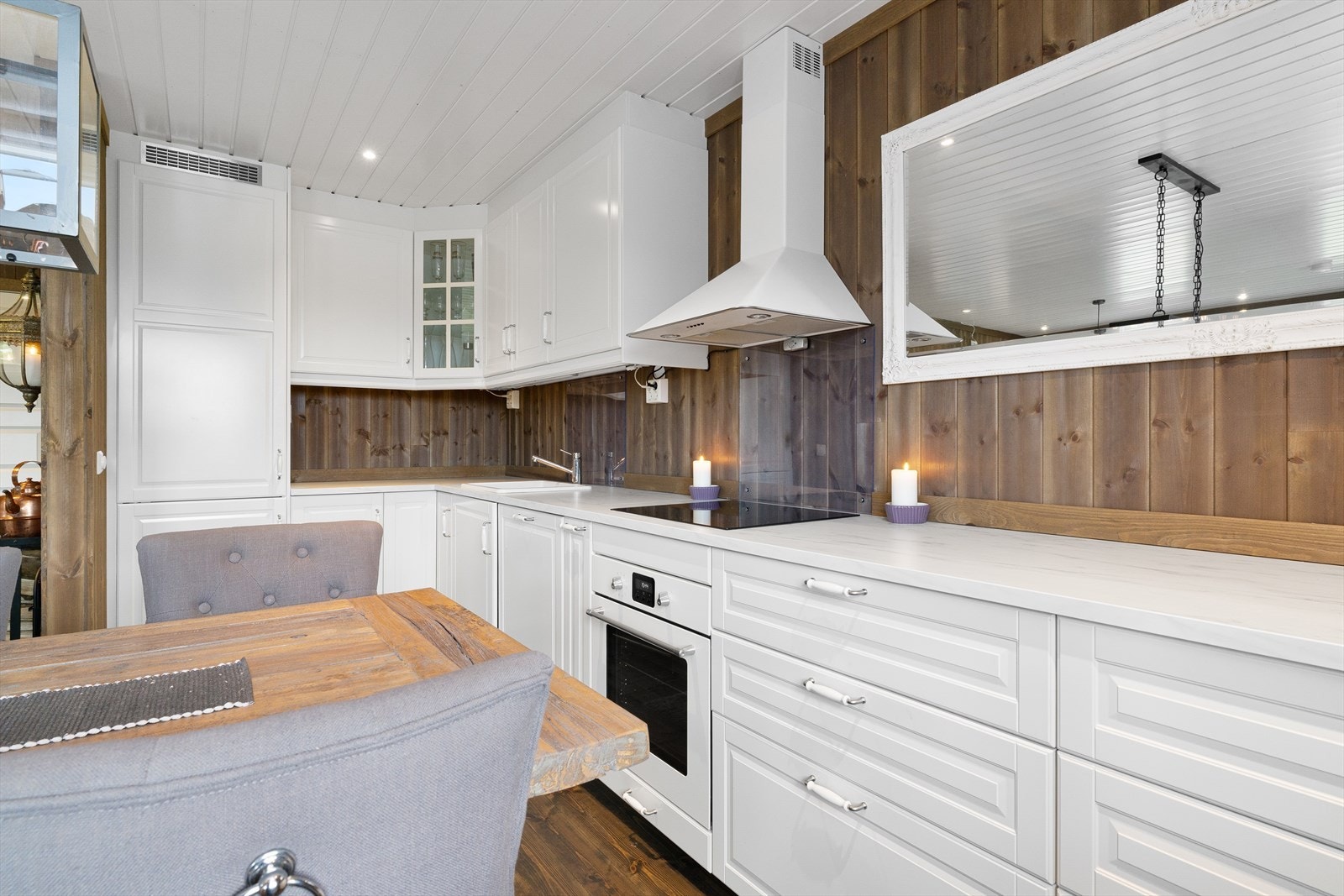 Et lekkert kjøkken med profilert innredning og hvite detaljer. Integrerte hvitevarer medfølger. Galleribilde