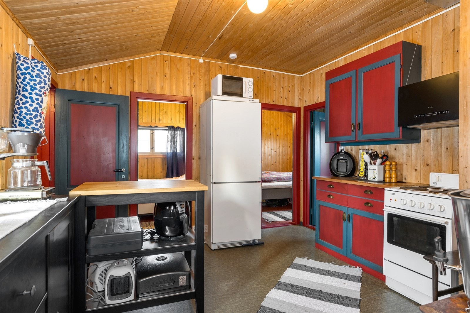 Enkel kjøkkeninnredning med laminat benkeplate, samt frittstående hvitevarer. Galleribilde