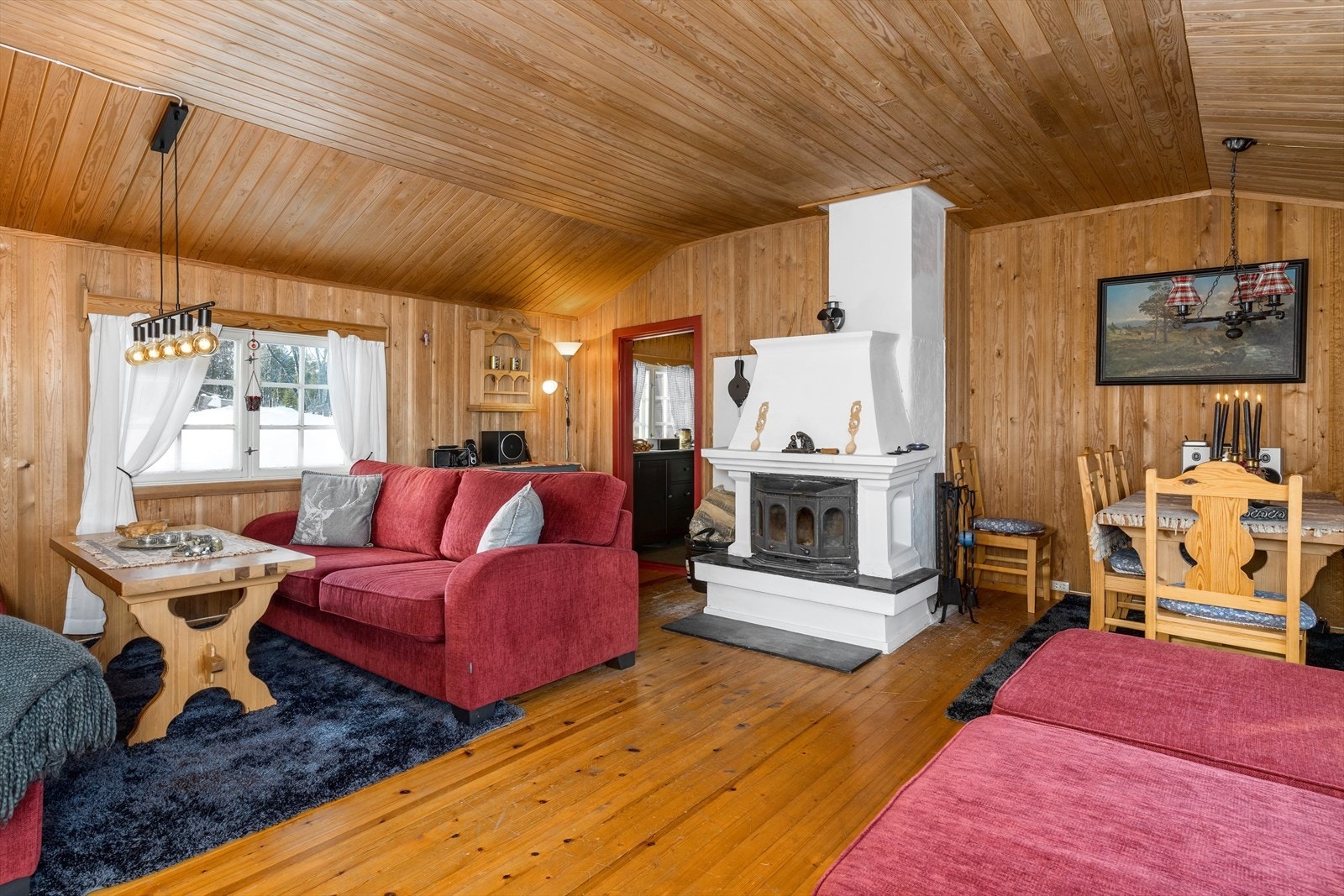 I stuen er det god plass til ønsket møblering. Peisen står sentralt i rommet og varmer godt opp i hytta. Galleribilde