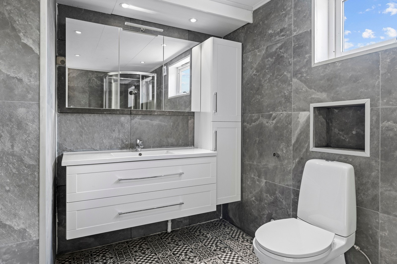 Over servanten er det montert et speil som bidrar til både romfølelse og funksjonalitet. Galleribilde