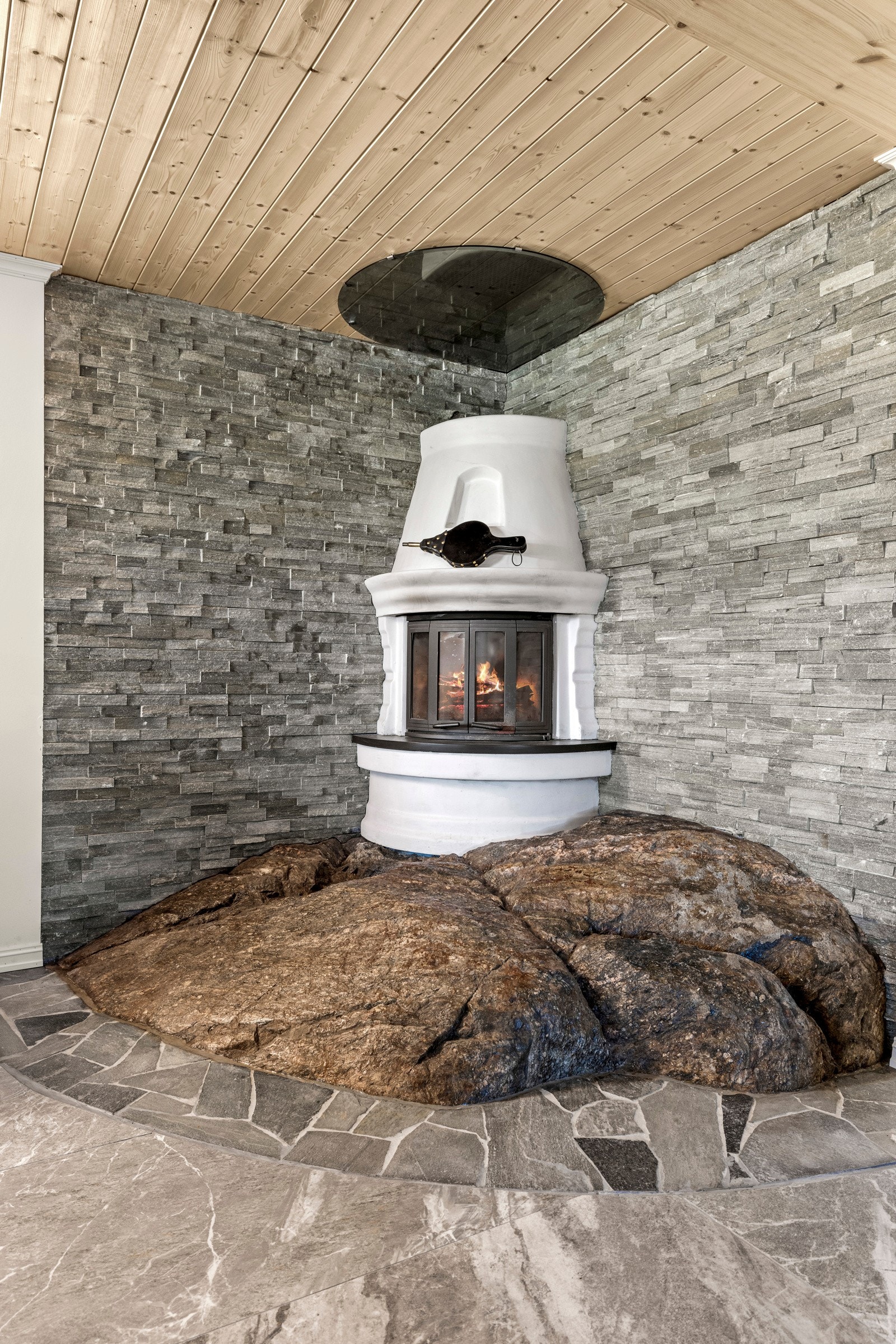 Stuen har peis med innsats på integrert fjell i kjeller og sotluke/feieluke. Dette gir stuen en sjelden detalj som gir både karakter og en naturlig varme til rommet. Galleribilde
