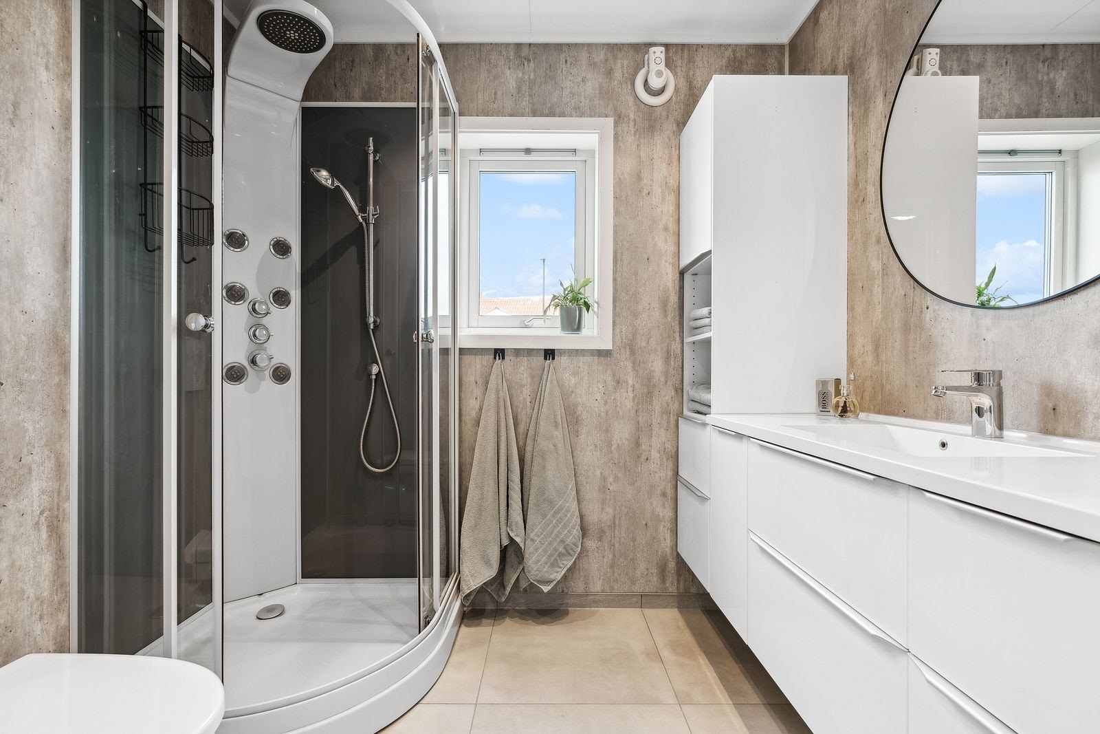 Delikat bad med våtromsplater og flislagt gulv. Godt med oppbevaringsplass. Galleribilde