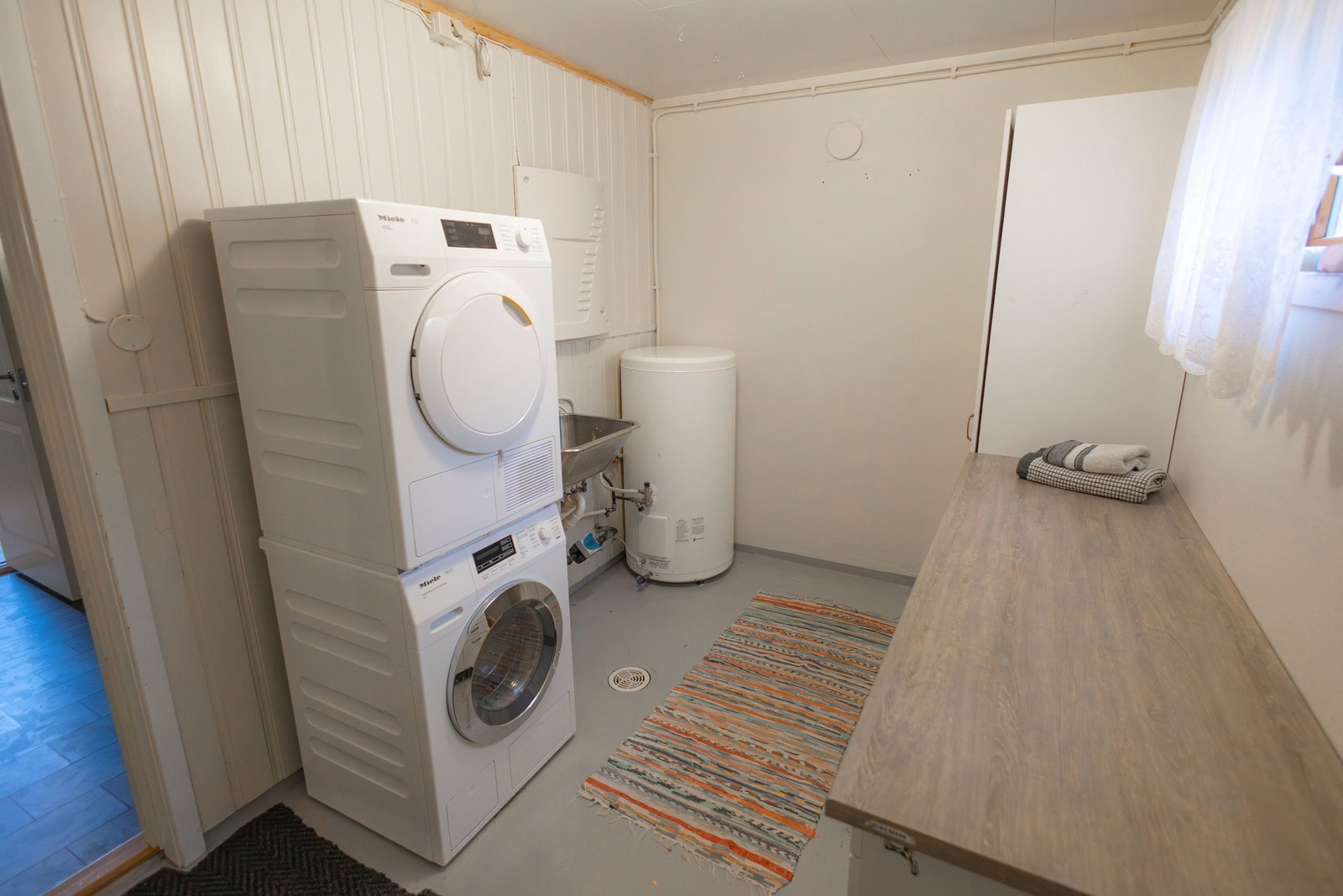 Vaskerom med utslagsvask, skap og benkeplate. Galleribilde