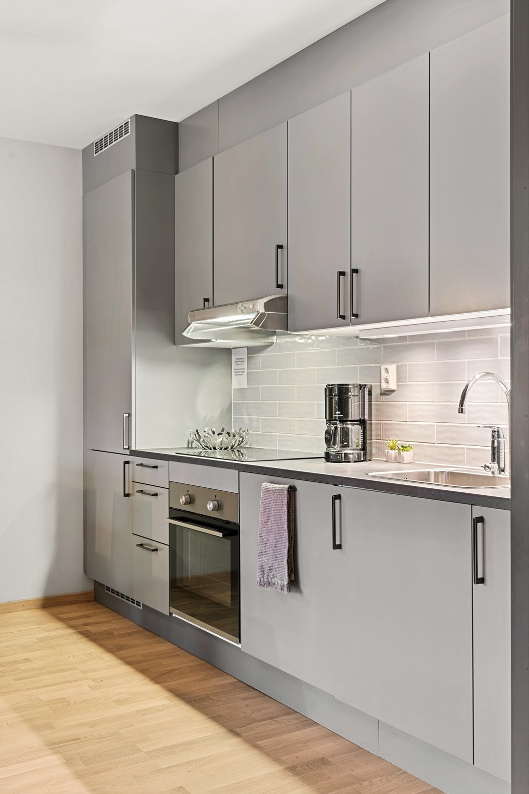 Moderne og arealeffektivt kjøkken med integrerte hvitevarer og god skapplass. Galleribilde