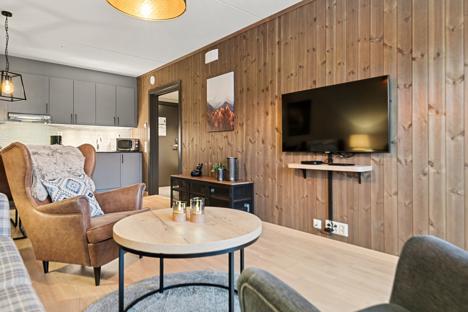 En fondvegg med trepanel gir stuen en lun og koselig atmosfære. Galleribilde