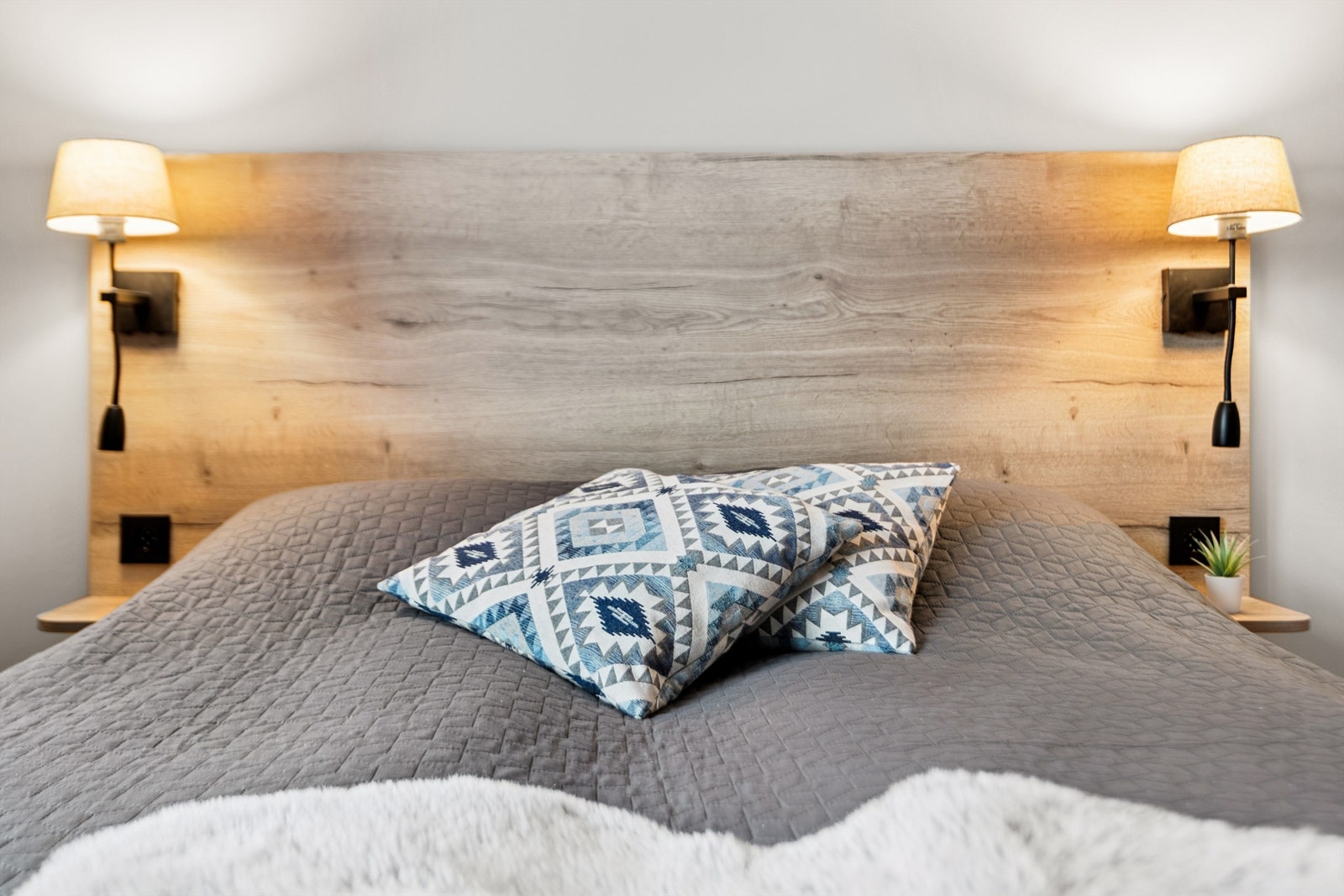 Praktisk sengegavl med integrerte nattbord og leselamper. Galleribilde