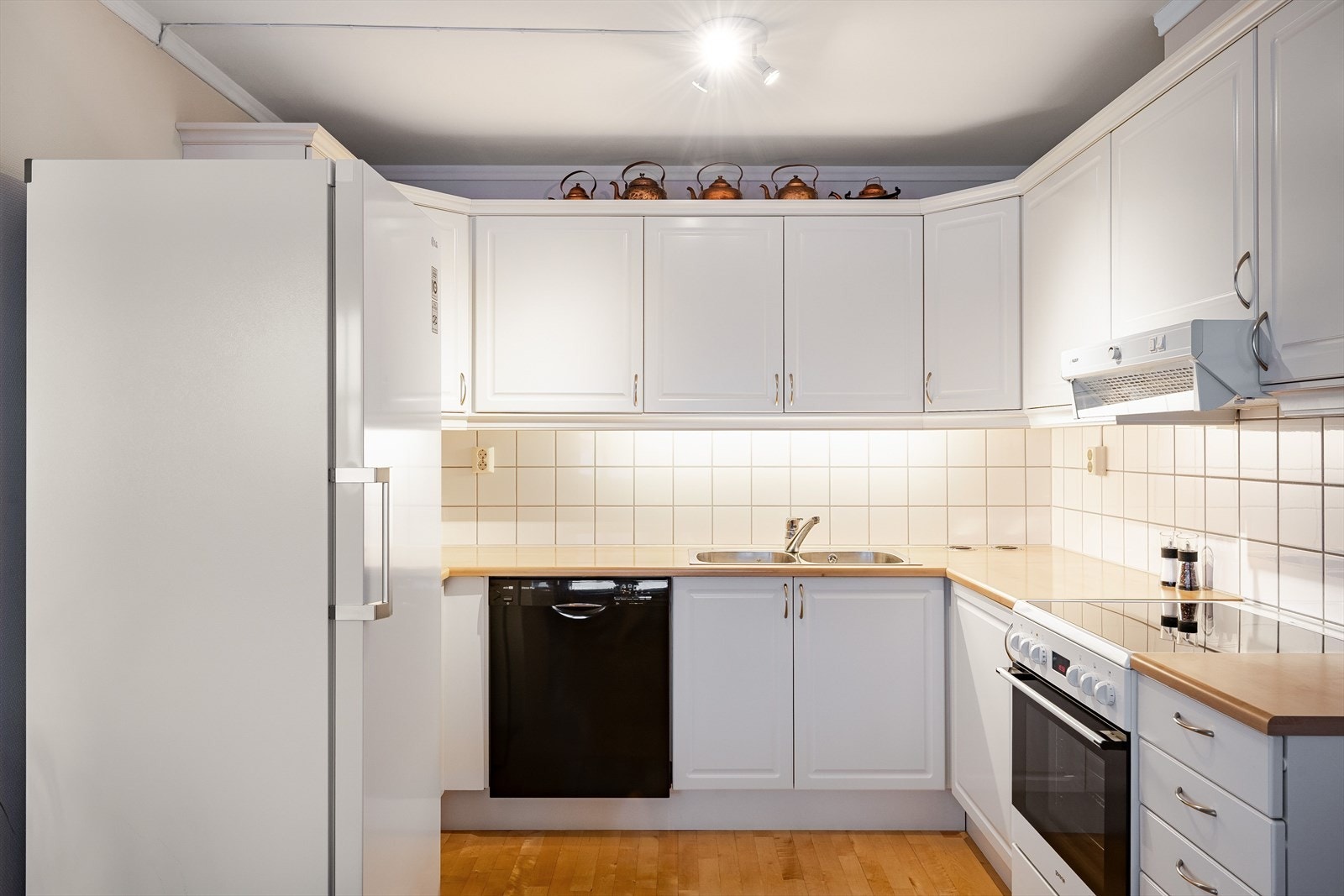 Det er godt med skap- og benkeplass på kjøkkenet som har åpent løsning for hvitevarer. Galleribilde