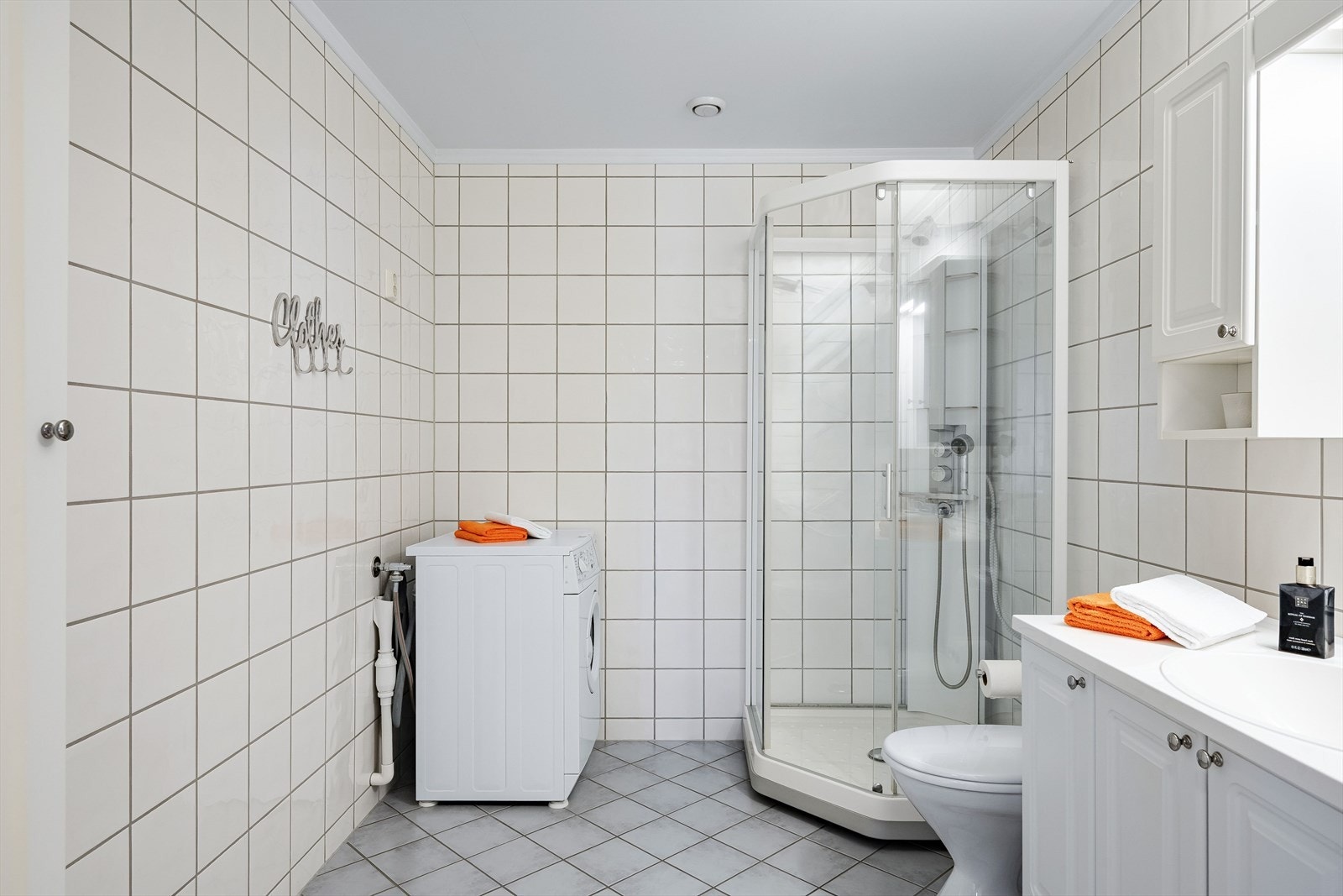 Flislagt baderom med varmekabler i gulvet og opplegg for vaskemaskin. Galleribilde