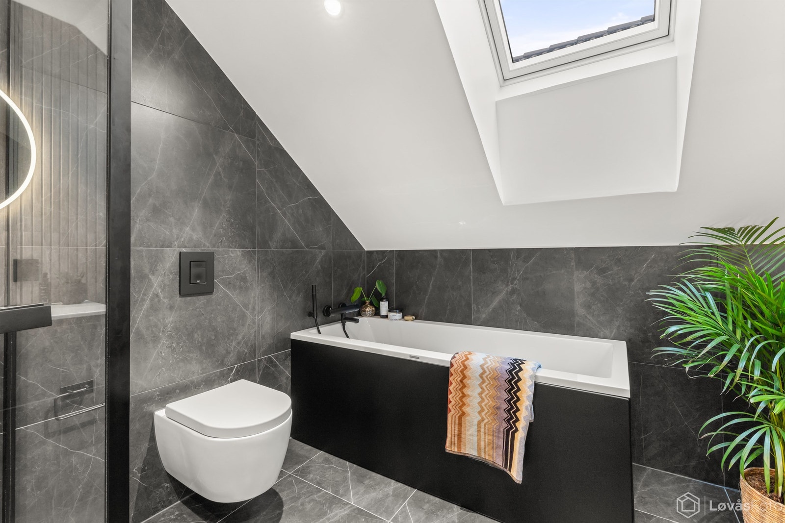 Badet er utstyrt med badekar, og takvinduet gir et behagelig lys. Galleribilde