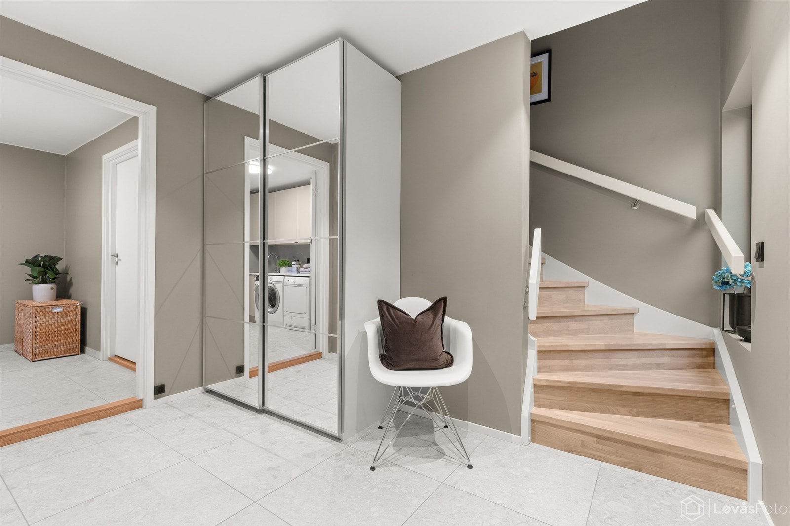 Praktisk skyvedørsgarderobe og en trapp i hvitpigmentert eik som leder oppover i etasjene. Galleribilde