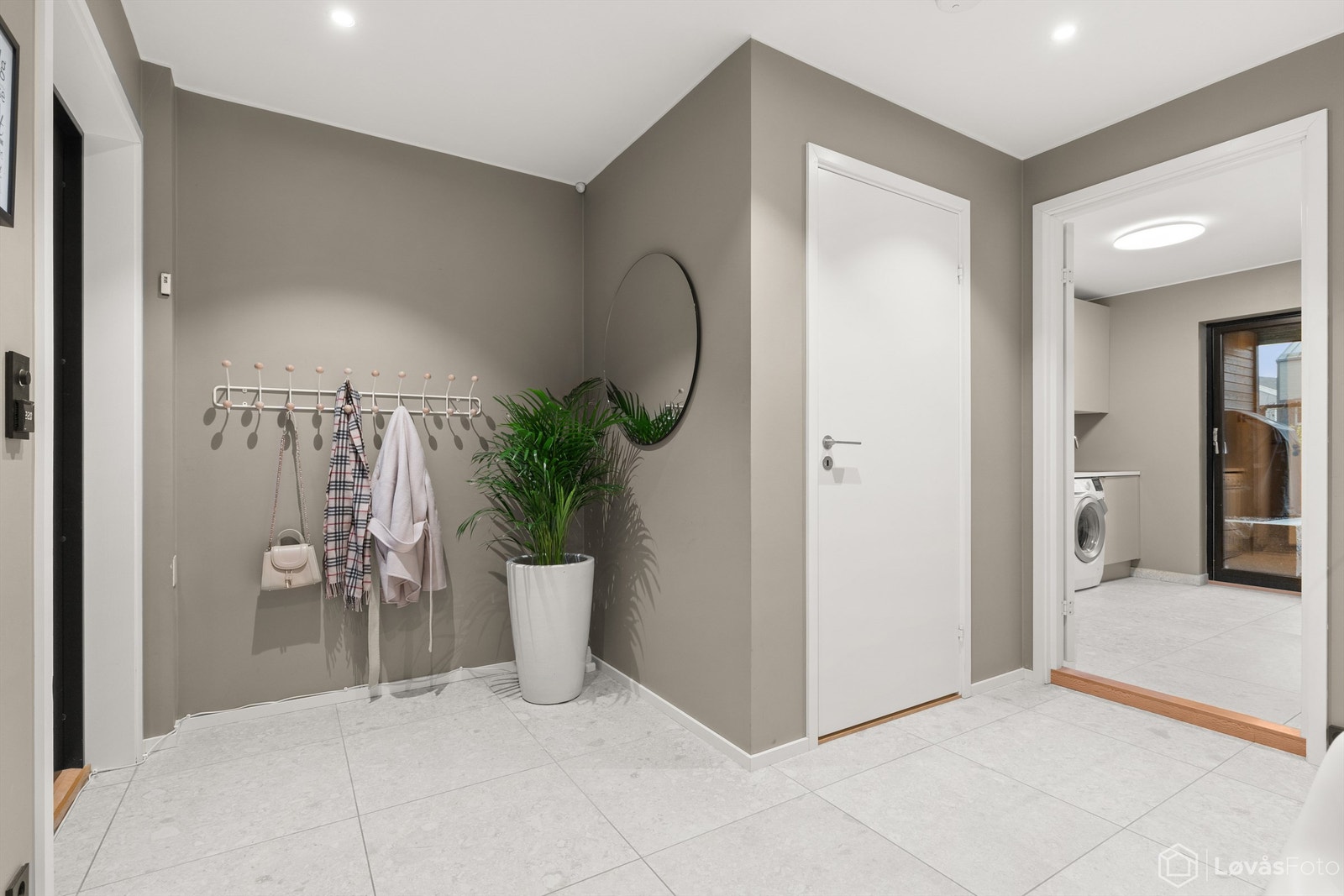 En lys og innbydende entré med store 60x60 fliser og downlights i himlingen. Galleribilde