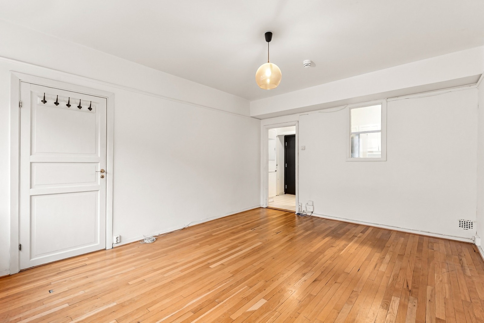 Stuen har klassiske detaljer som heltre tregulv og generøs takhøyde, noe som gir rommet et tidløst uttrykk og et solid utgangspunkt for videre oppgradering. Galleribilde