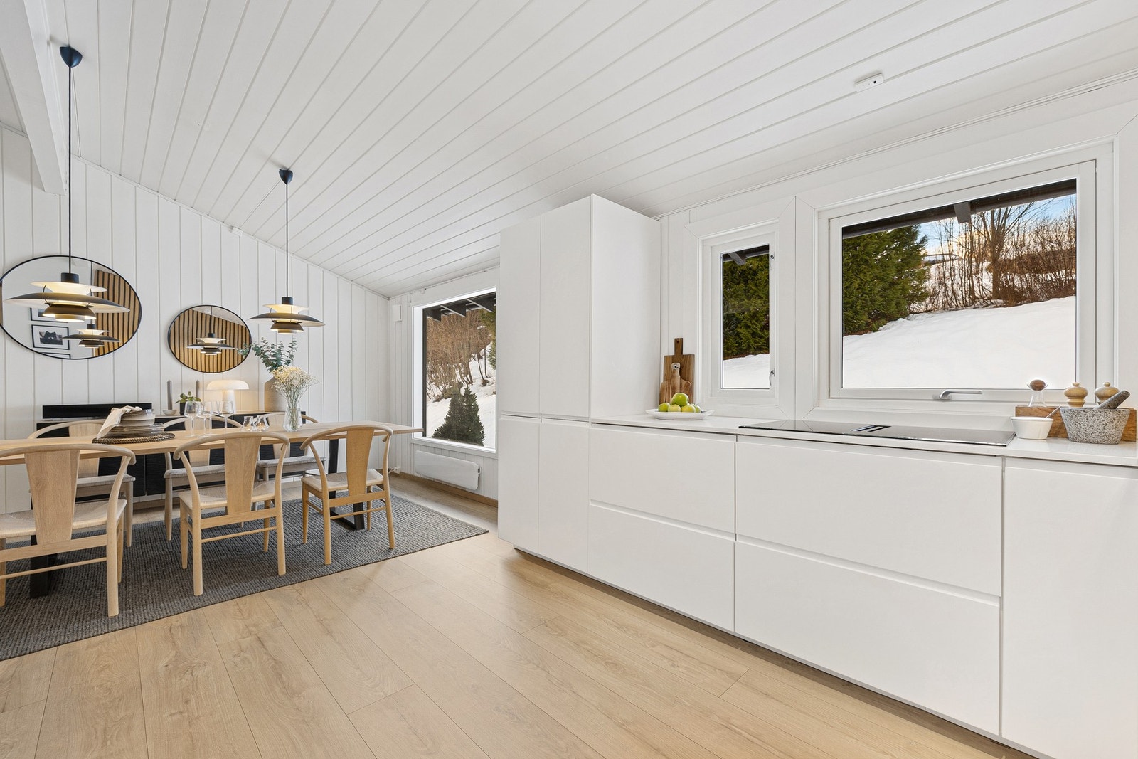 Kjøkkeninnredningen har lyse, slette fronter og slitesterk benkeplate i kvartskompositt. Induksjonstoppen med integrert avtrekk gir kjøkkenet et minimalistisk preg. Galleribilde