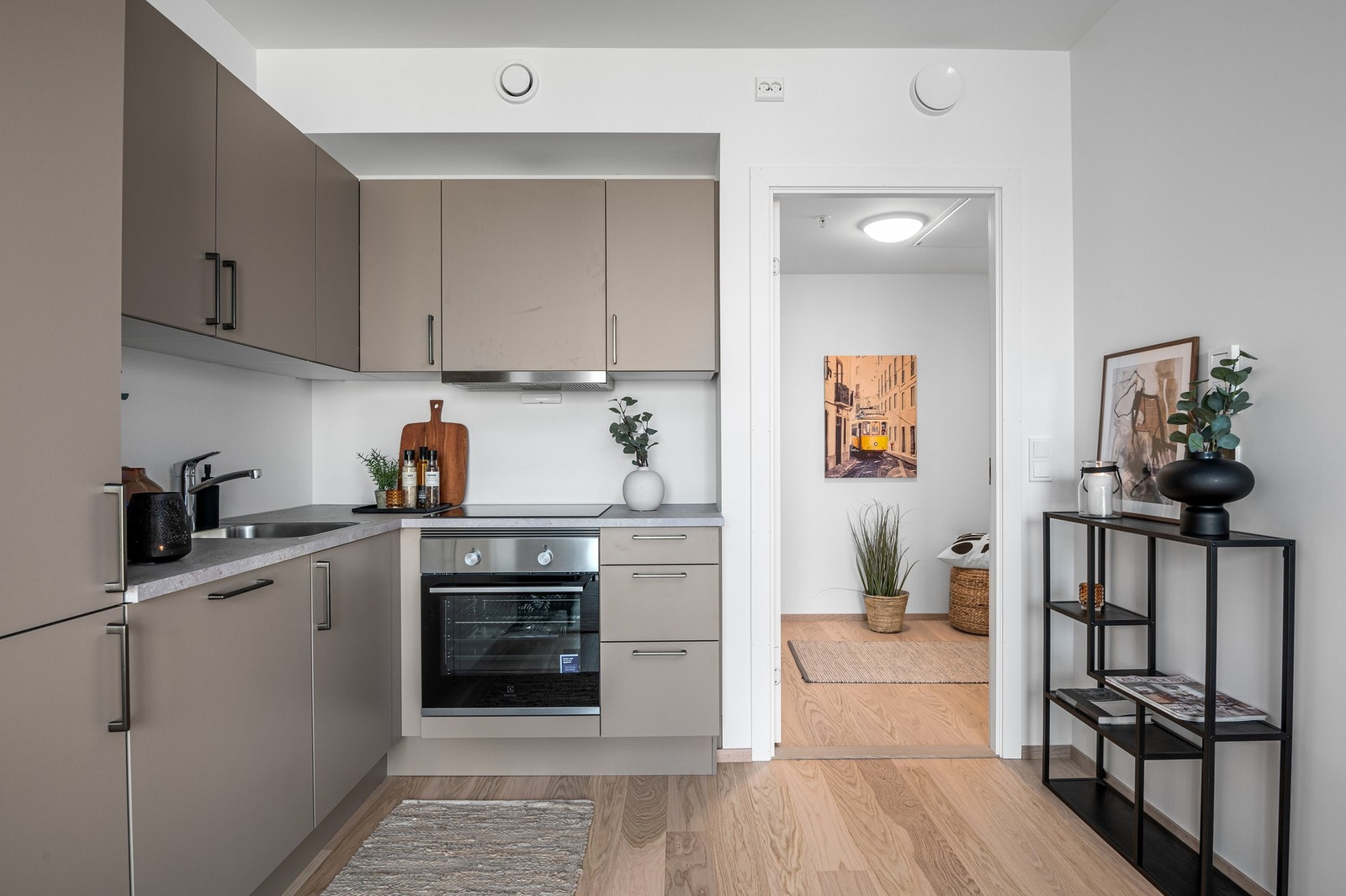 Vinklet og stilren kjøkkeninnredning med integrerte hvitevarer. Galleribilde