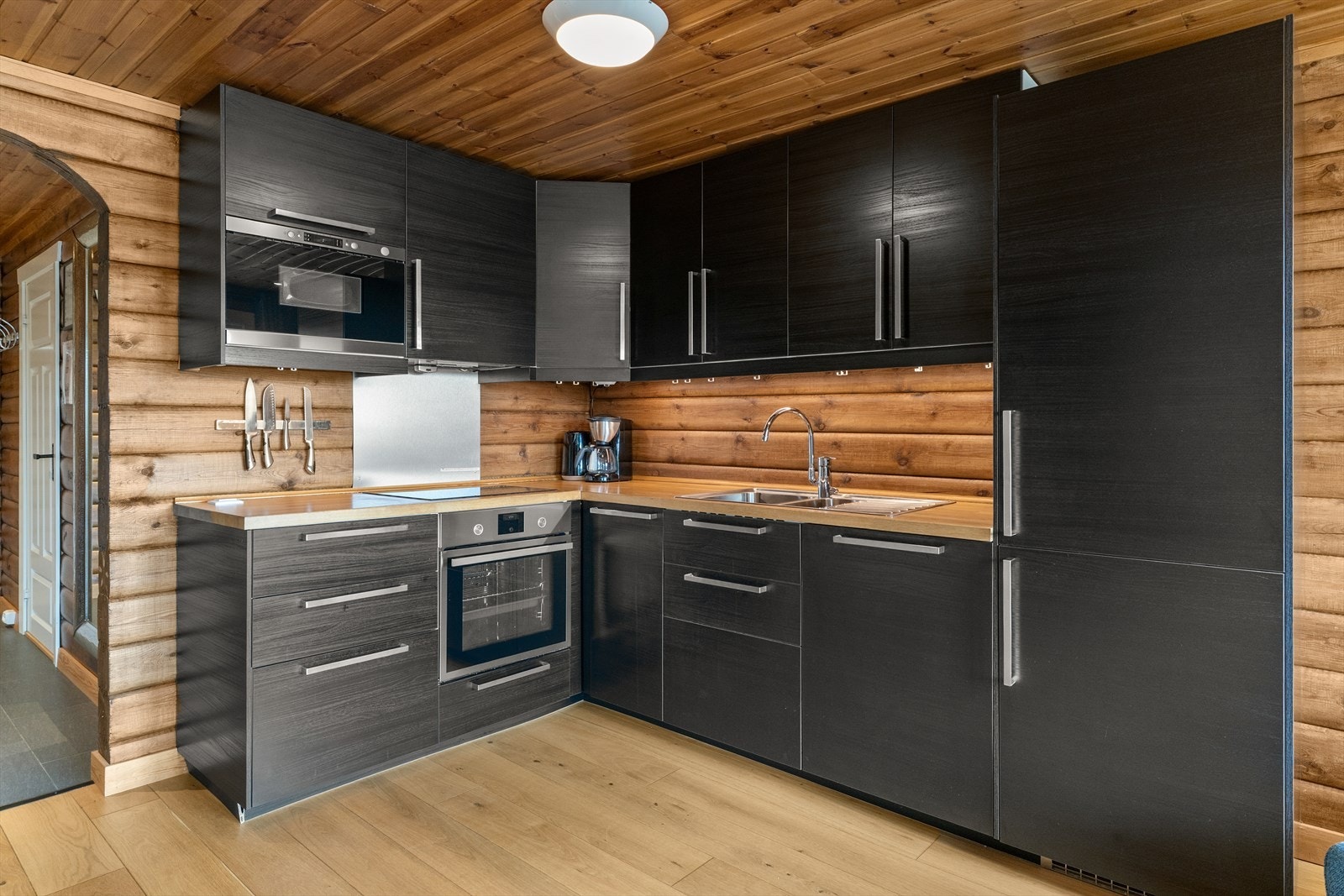 Kjøkken med integrerte hvitevarer og god plass til oppbevaring i skap. Galleribilde