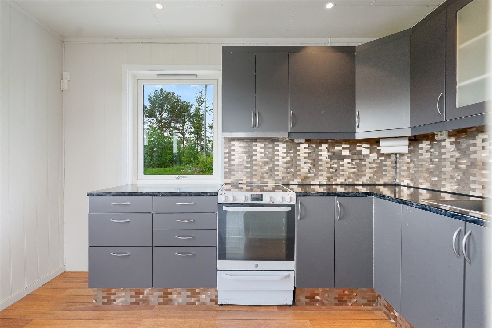 Kjøkkeninnredning med slette folierte fronter og laminat benkeplate med nedfelt oppvaskkum. Galleribilde