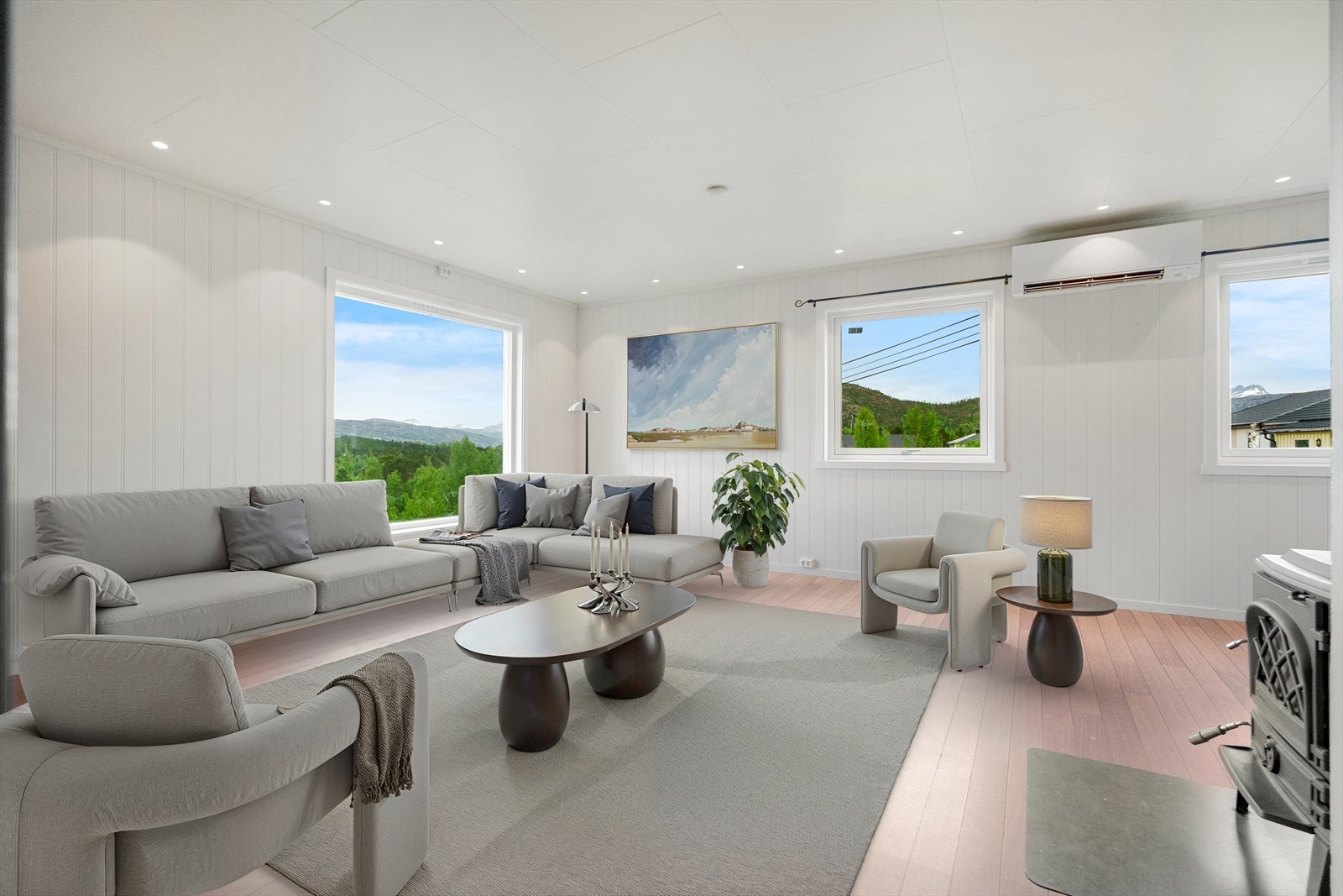 Romslig stue med store vindusflater som slipper inn godt med dagslys til boligen. (Digitalt møblert) Galleribilde