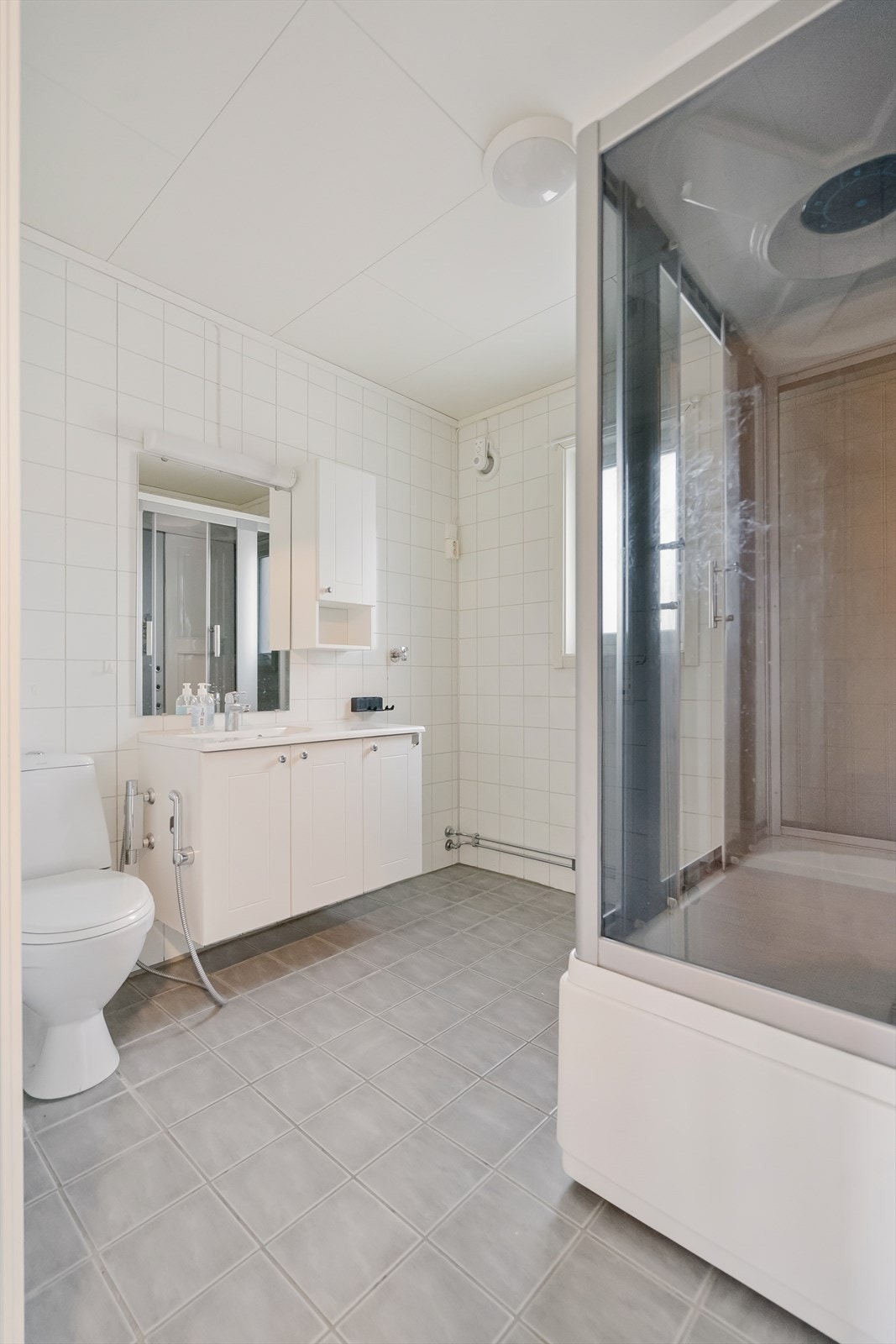 Badet har våtromsplater på vegg og fliser på gulv. Galleribilde