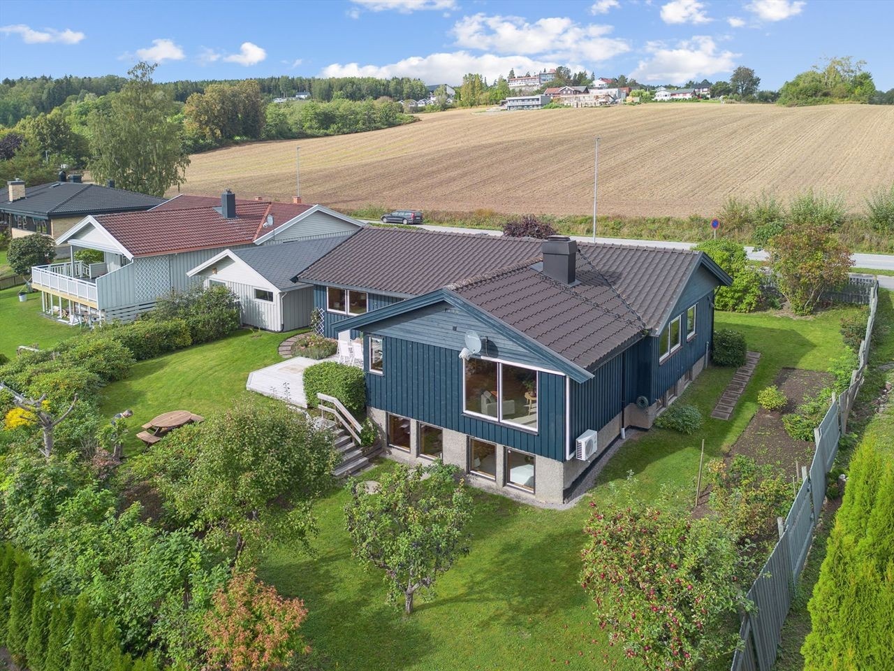 Tomten er opparbeidet med plen, samt beplantet med busker og trær. Galleribilde