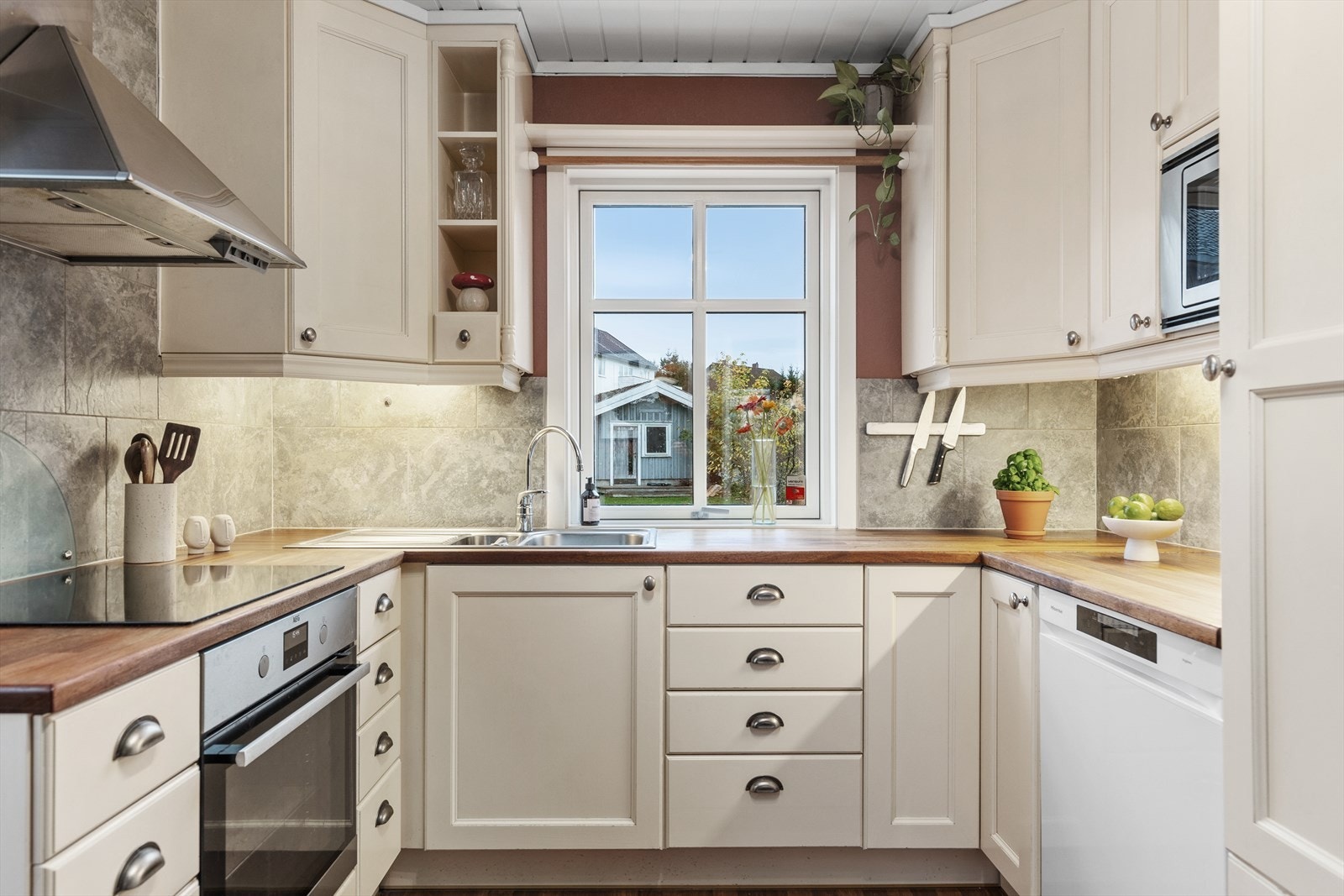 Kjøkkenet måler 10,5 m² og innredningen består av benkeplate i heltre, profilerte fronter og integrerte hvitevarer. Galleribilde