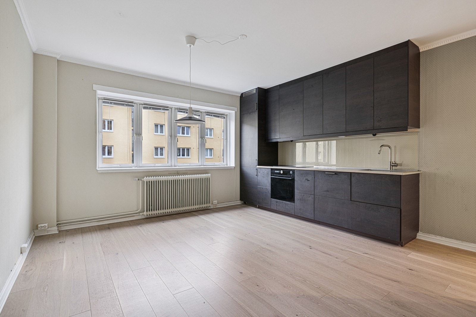 Pent kjøkken med integrerte hvitevarer og åpen løsning mot stue. Galleribilde