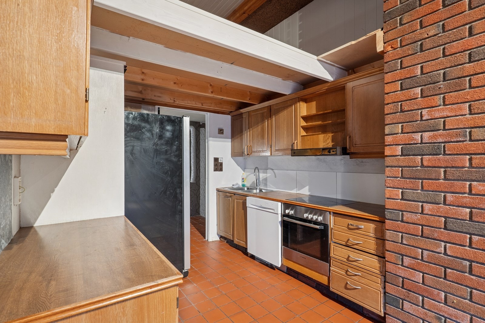 Eldre kjøkken med profilerte eikefronter og benkeplate av typen laminat. Galleribilde