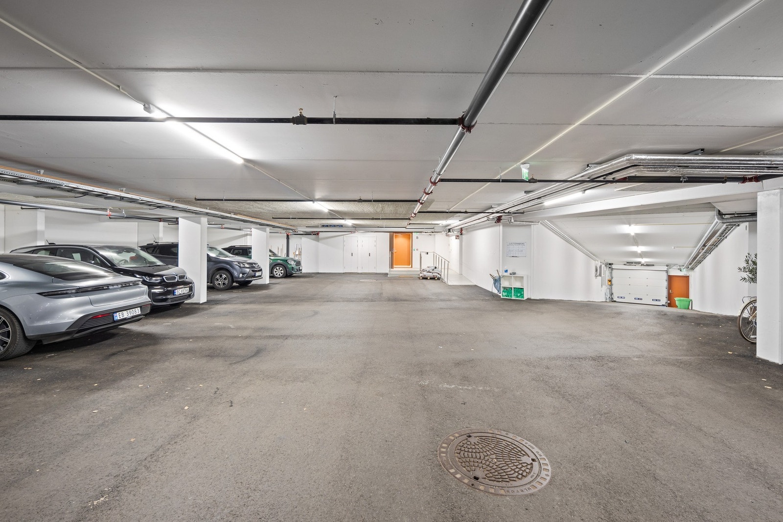 Garasjekjeller. Denne leiligheten har garasjeplass nummer 19, som er den sølvgrå bilen lengst til venstre i bildet. Galleribilde