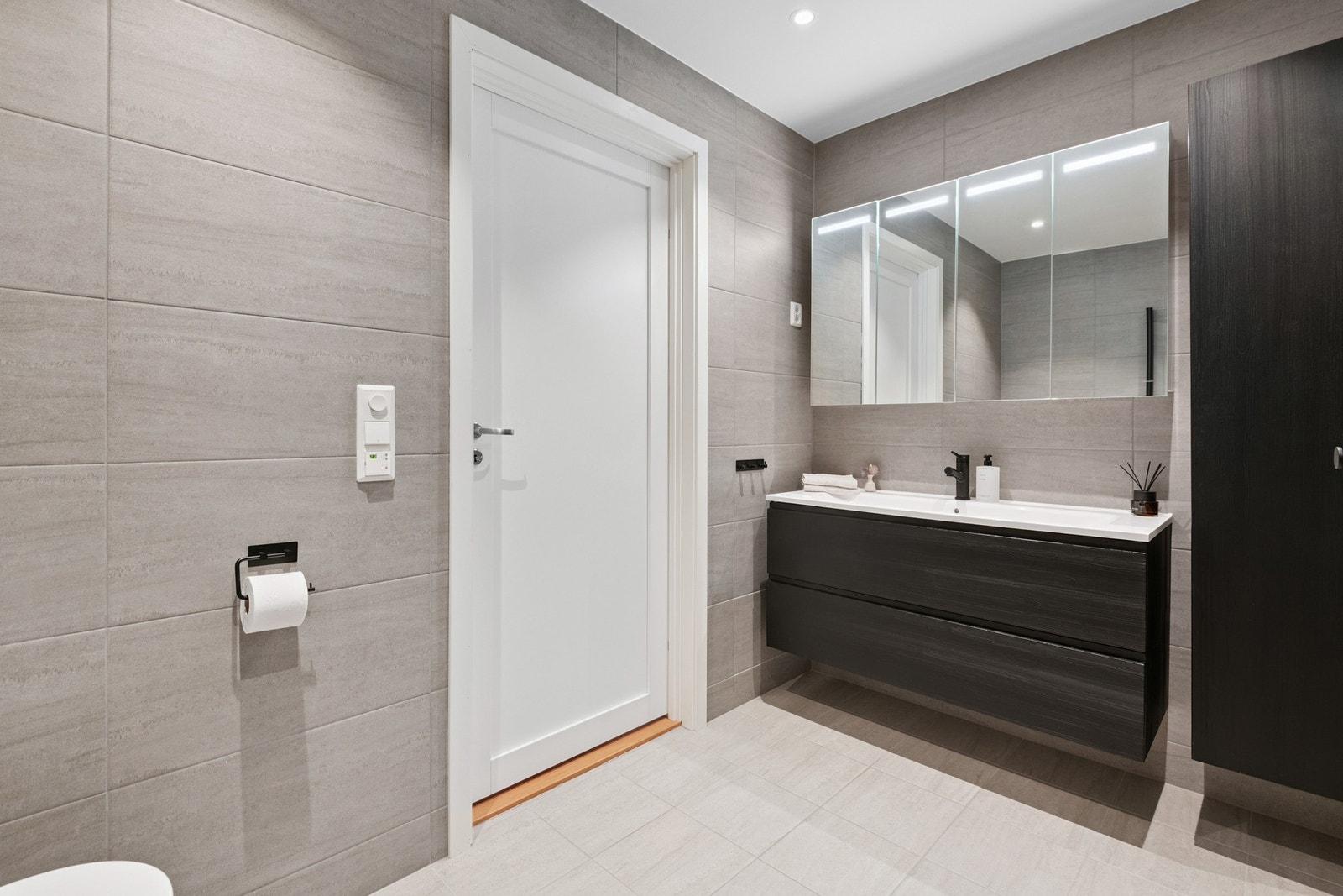 Stilrent bad med svarte detaljer, speilskap med lys og høyskap Galleribilde