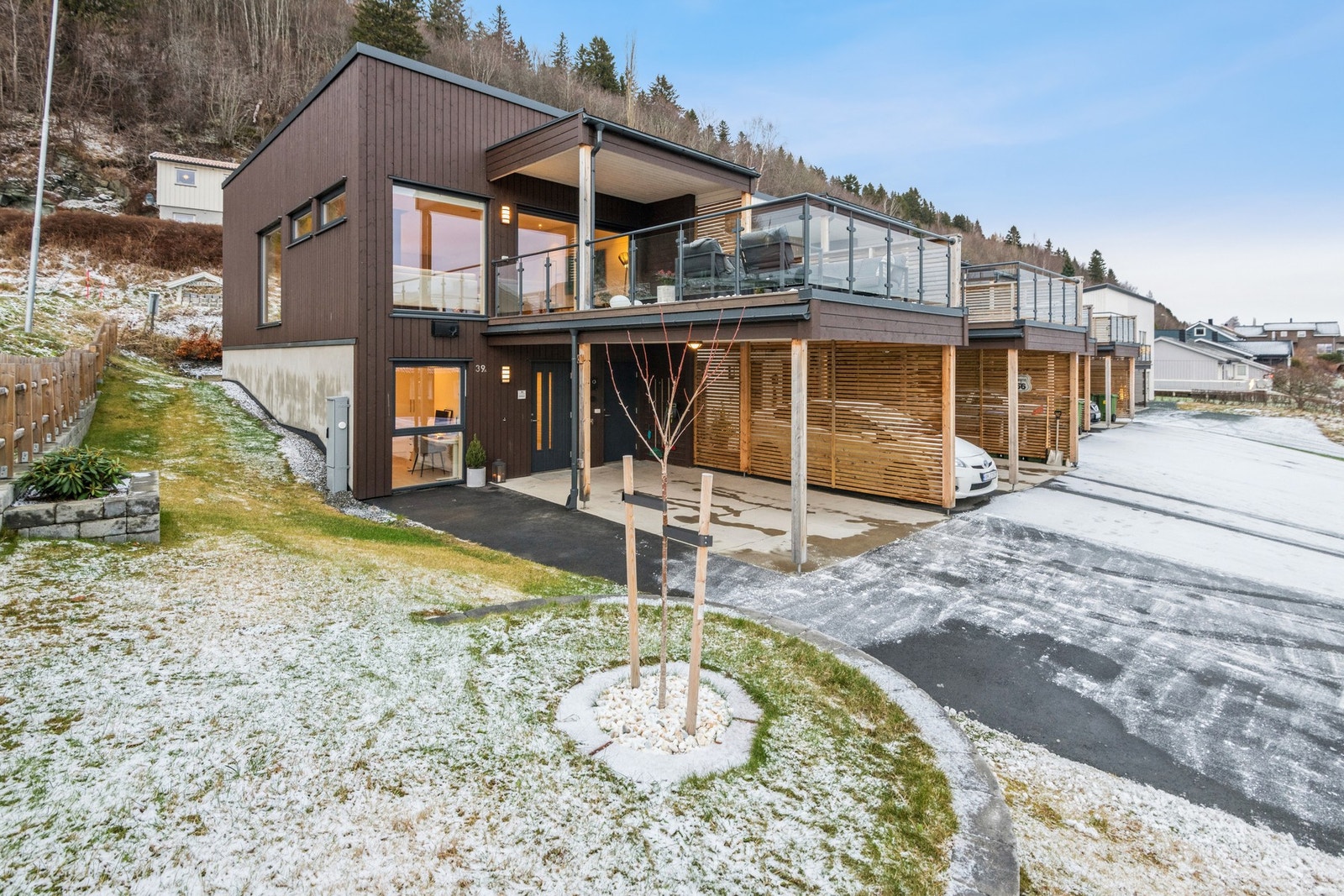 Boligen har takoverbygget inngangsparti/ carport med installert elbillader. Galleribilde