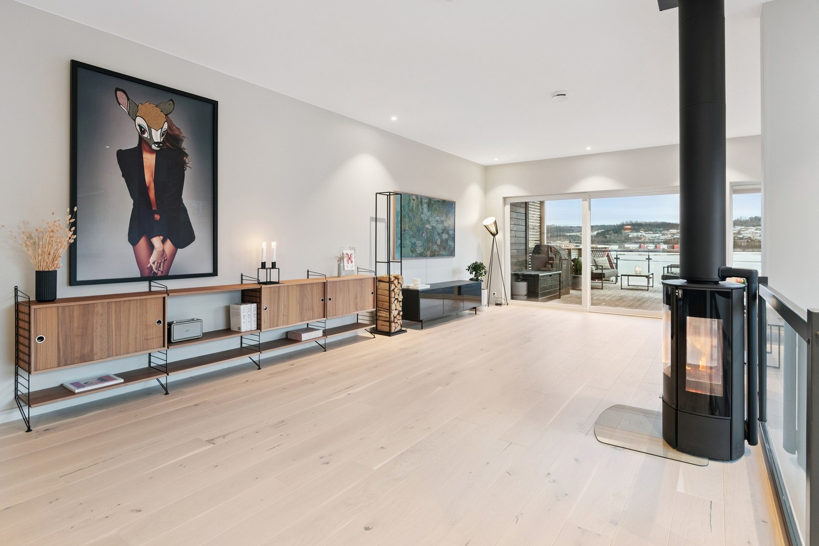 Lys og romslig stue med god takhøyde. Eksklusiv Rais-peis med glass på 3 sider. Galleribilde