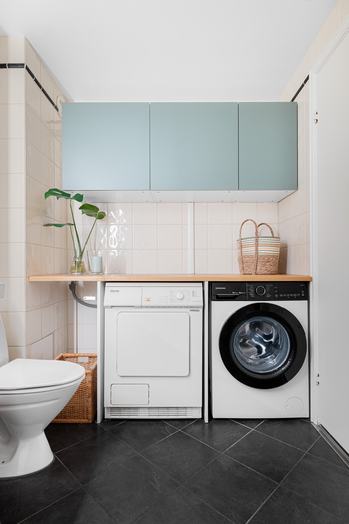 En praktisk benkeplate gir god arbeidsflate, blant annet for sortering og bretting av klær, og under benken er det plass til både vaskemaskin og tørketrommel. Galleribilde