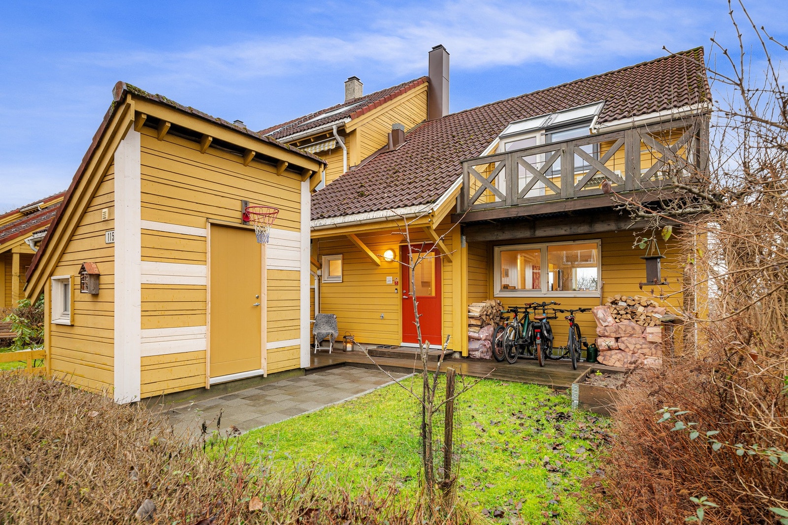 Ved inngangspartiet ligger en terrasseplatting på ca. 18 m² med praktisk utebod - perfekt for den aktive familie. Galleribilde