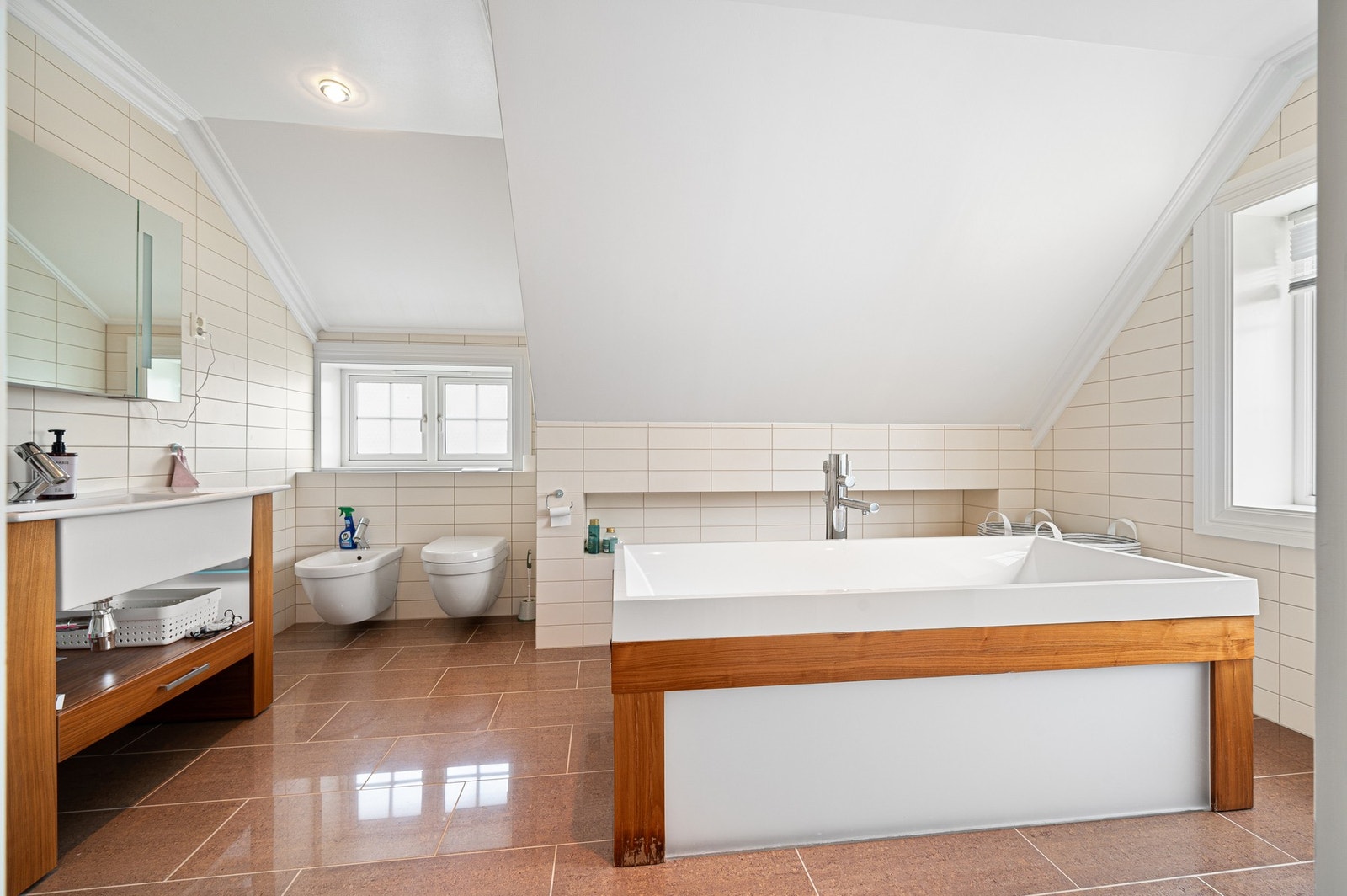 Stort og lyst baderom med god plass, badekar og tidløse flater. Galleribilde