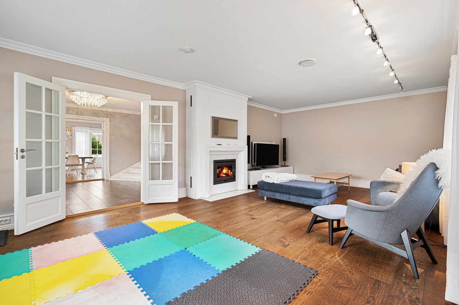 Stor stue med peis og doble dører mot hallen. Galleribilde