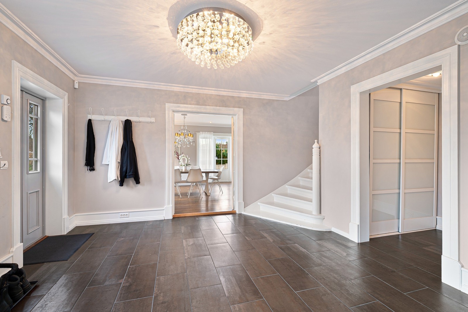 Romslig entré med flislagt gulv, god oppbevaringsplass og naturlig flyt inn mot oppholdsrommene. Galleribilde