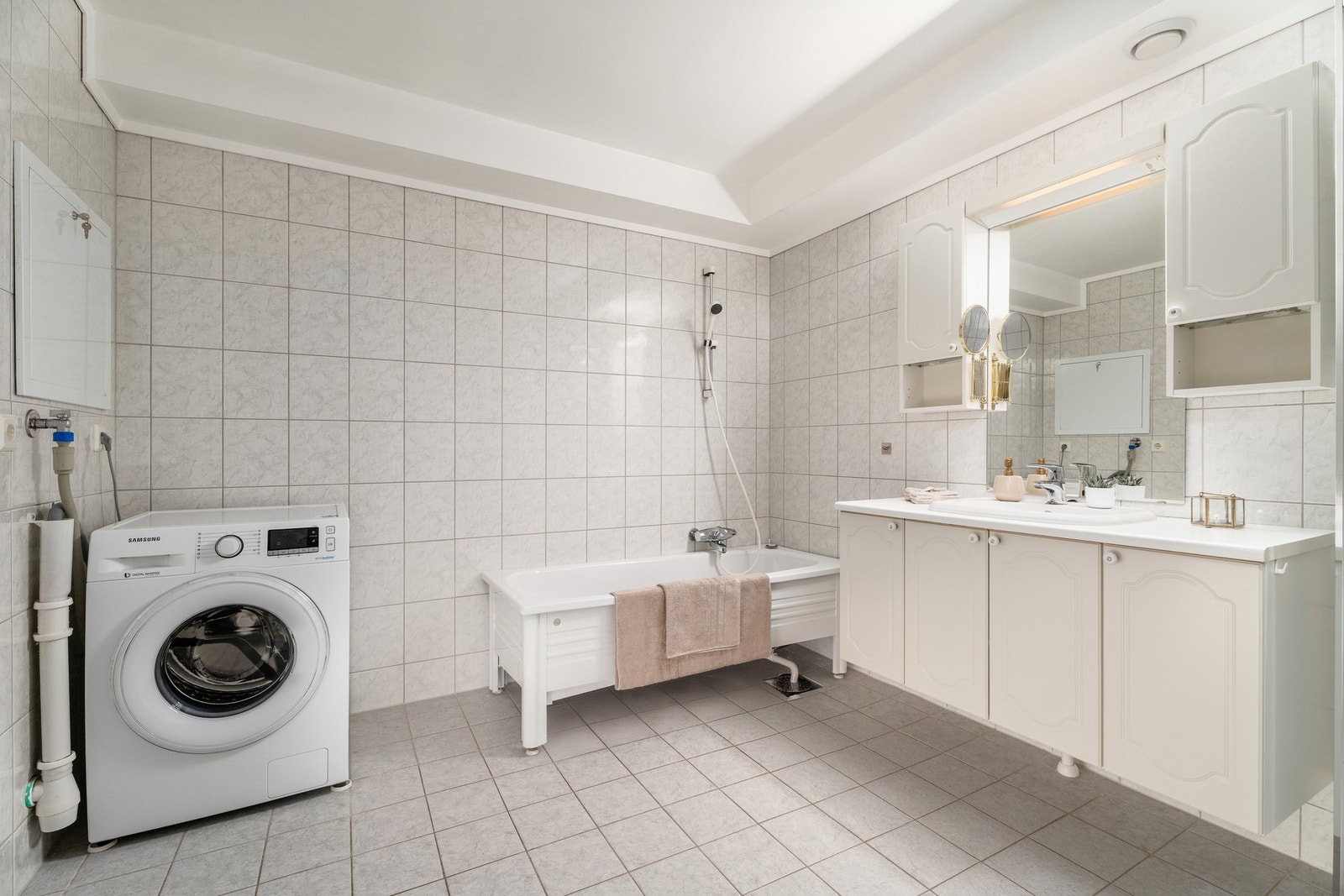 Det flislagte badet har gulvvarme og er romslig nok både til innholdsrik servantinnredning, badekar og vaskemaskin. Galleribilde