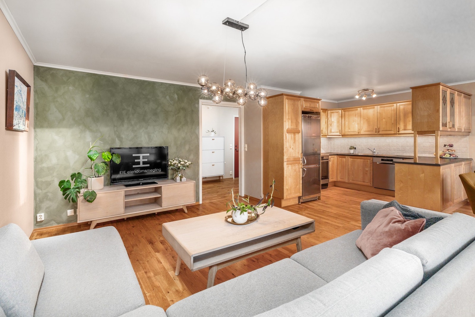 Åpen løsning mellom stue og kjøkken med god plass til sofakrok og TV-benk. Galleribilde