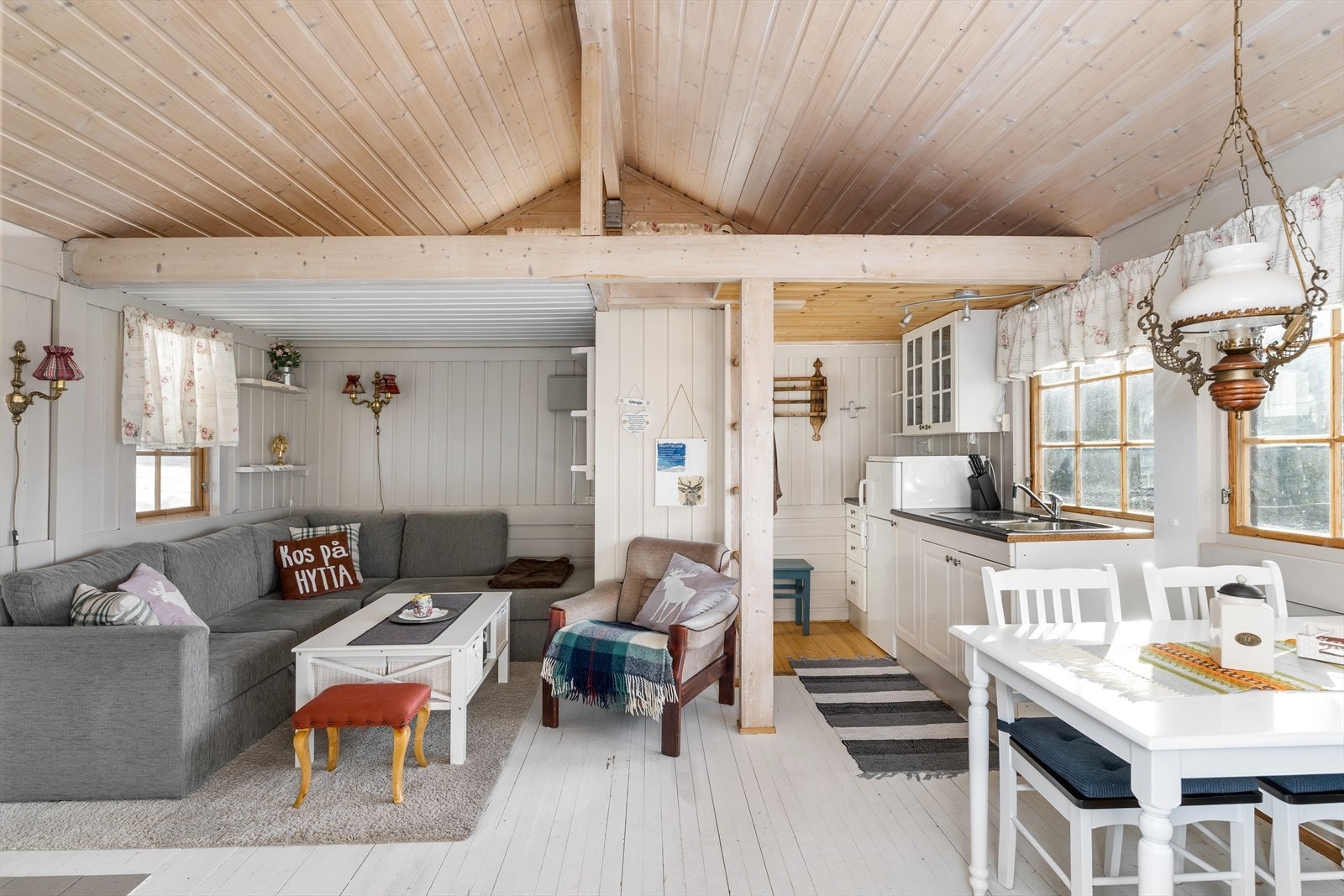 Åpen-stue kjøkkenløsning med god plass til spisegruppe, sofa og tilhørende møblement. Fra stuen er det en stige opp til hemsen. Galleribilde