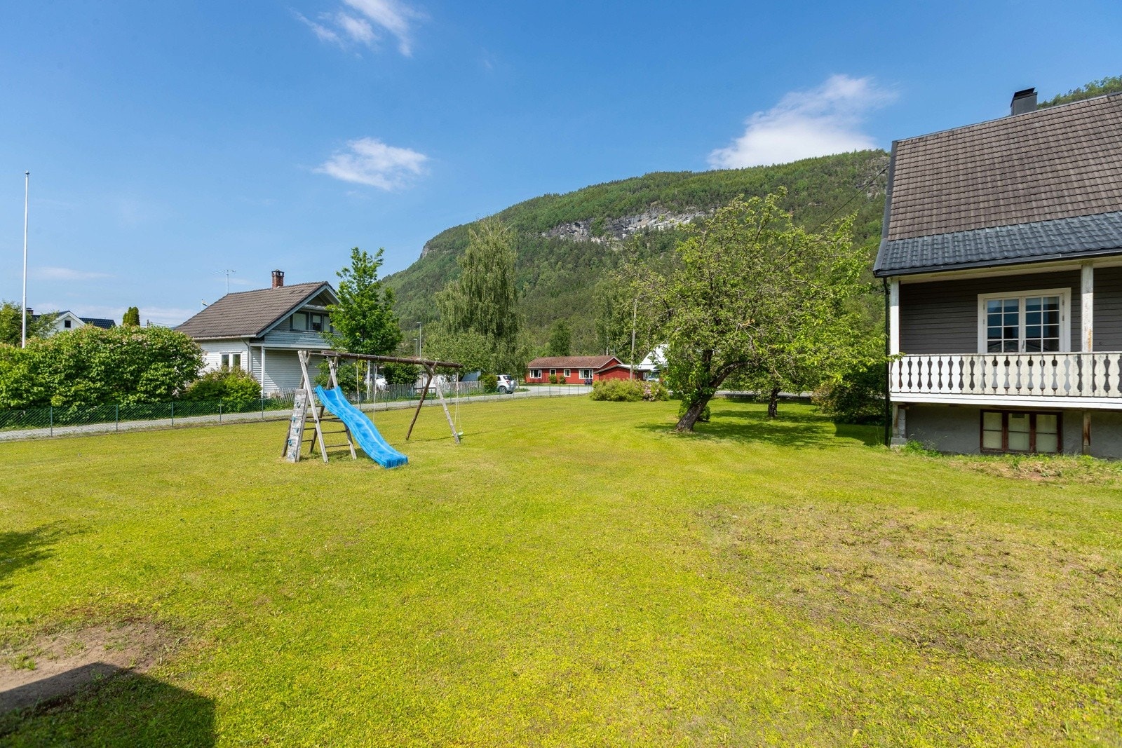 Eigedomen har stor flat tomt med plen Galleribilde