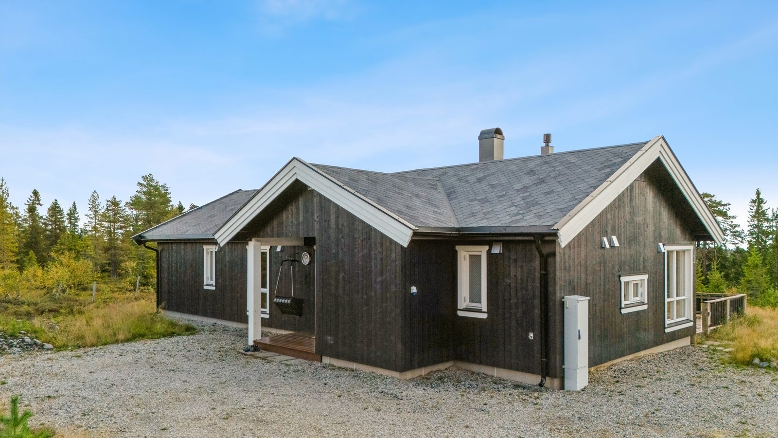 Hytta har et pent, overbygd inngangsparti med gruslagt adkomst og tilliggende utebod. Galleribilde