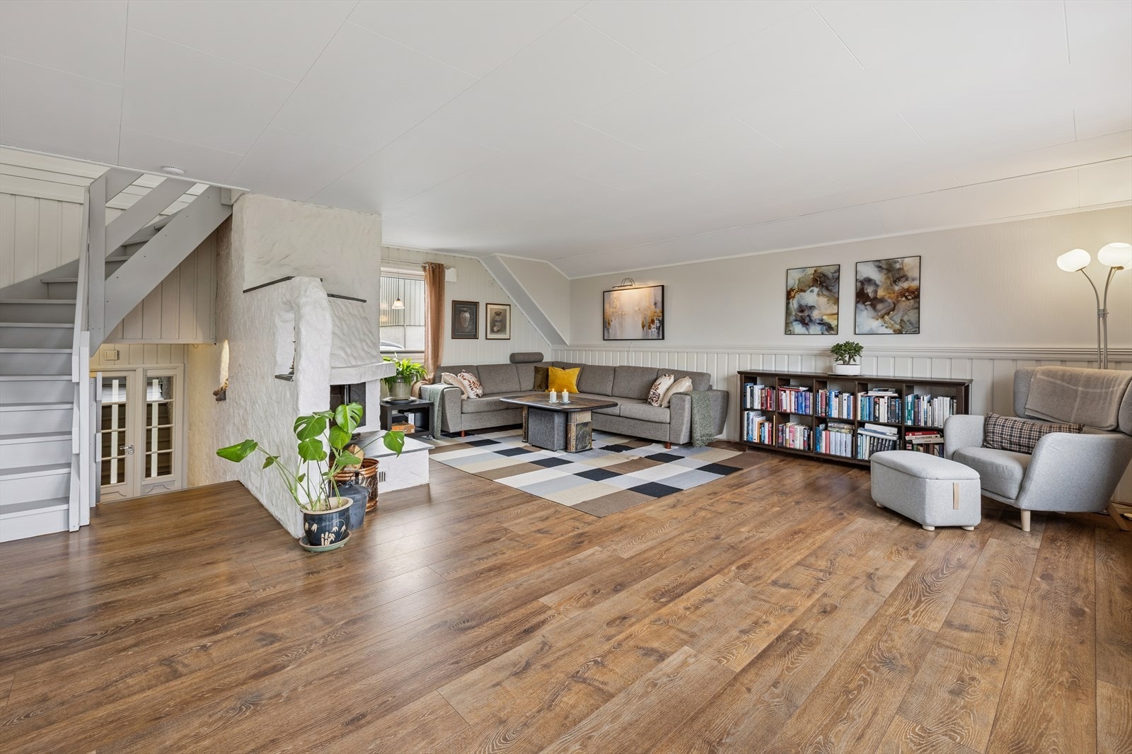 Trappen i mellometasjen fører videre opp til boligens første etasje, hvor du finner en romslig og lys stue. Galleribilde