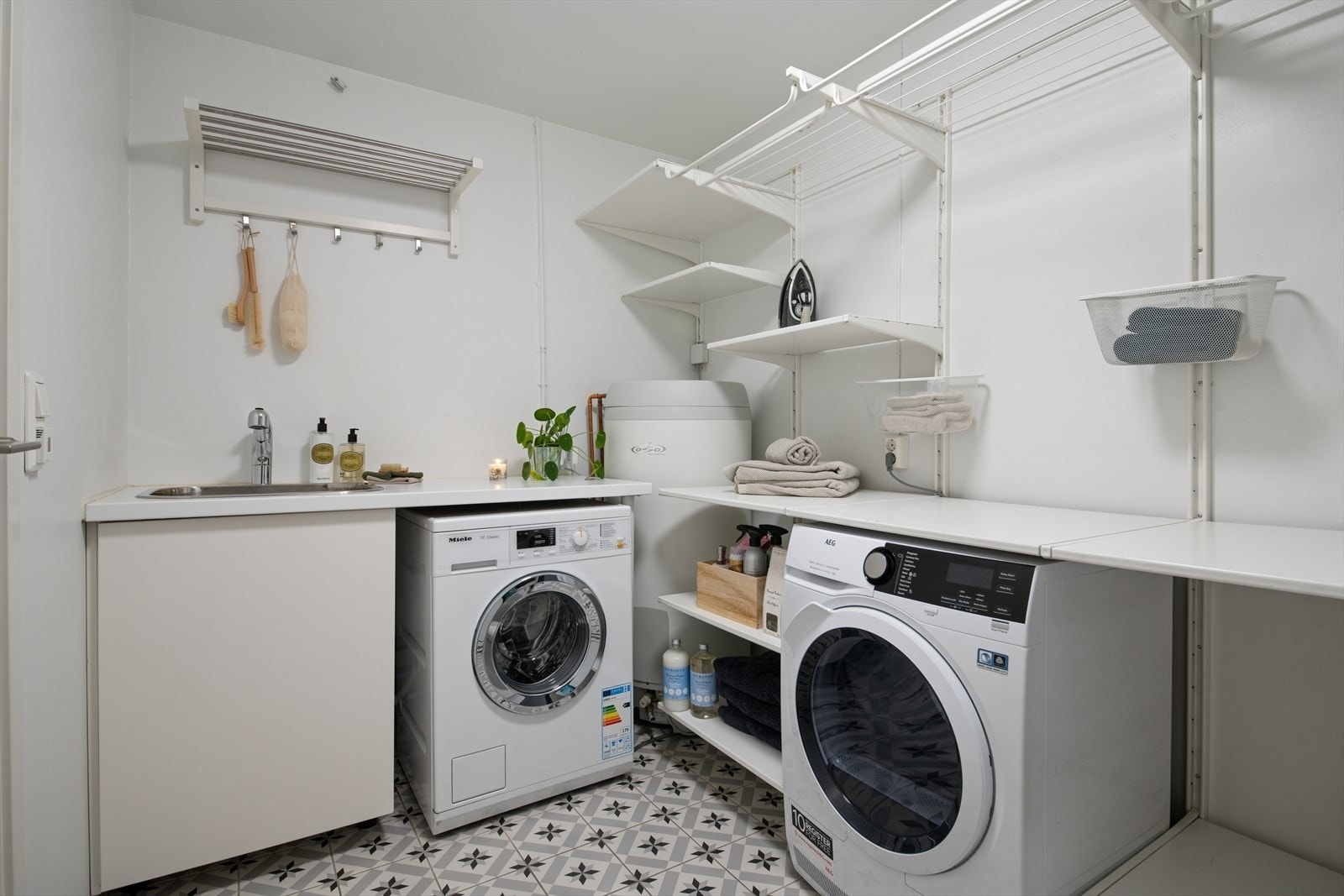 Vaskerommet ble pusset opp i 2018 og er innredet i tilsvarende stil som badet. Rommet er ellers utstyrt med vask, god lagringsplass i form av hyller og god benkeplass. I tillegg har man opplegg for vaskemaskin og plass til tørketrommel. Galleribilde