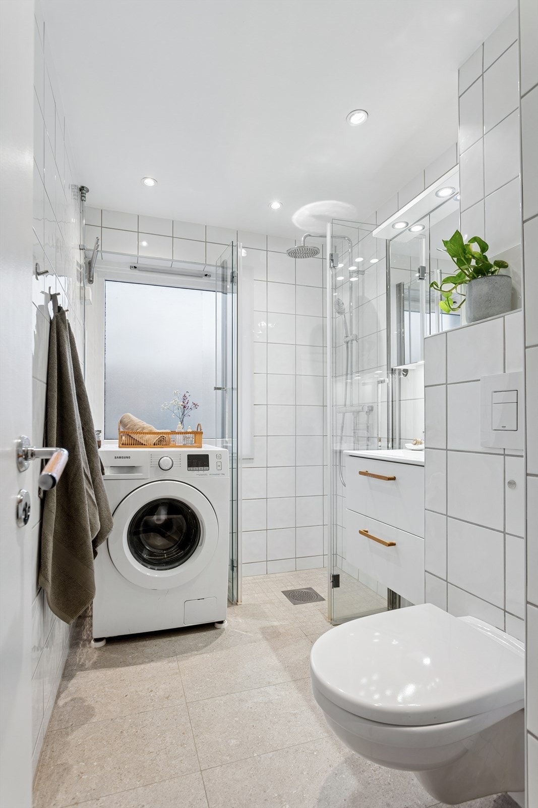 Det er praktisk opplegg for vaskemaskin. Badet har i tillegg vindu som gir naturlig lys og mulighet for effektiv lufting. Det er behagelig varme i gulv og downlights i himling. Galleribilde