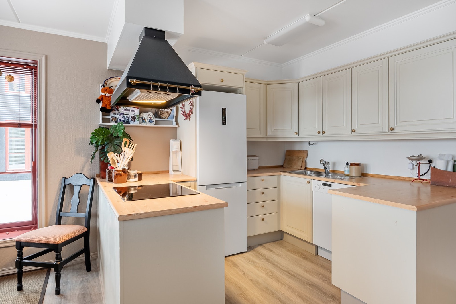 Kjøkkenet ligger i åpen løsning med stuen og spisestuen. Det er flott innredet med profilerte fronter malt i en lun og lys farge Galleribilde