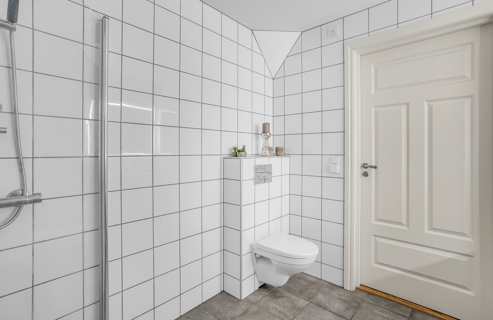 Badet er helfliset og utstyrt med vegghengt toalett med innebygd sisterne. Galleribilde