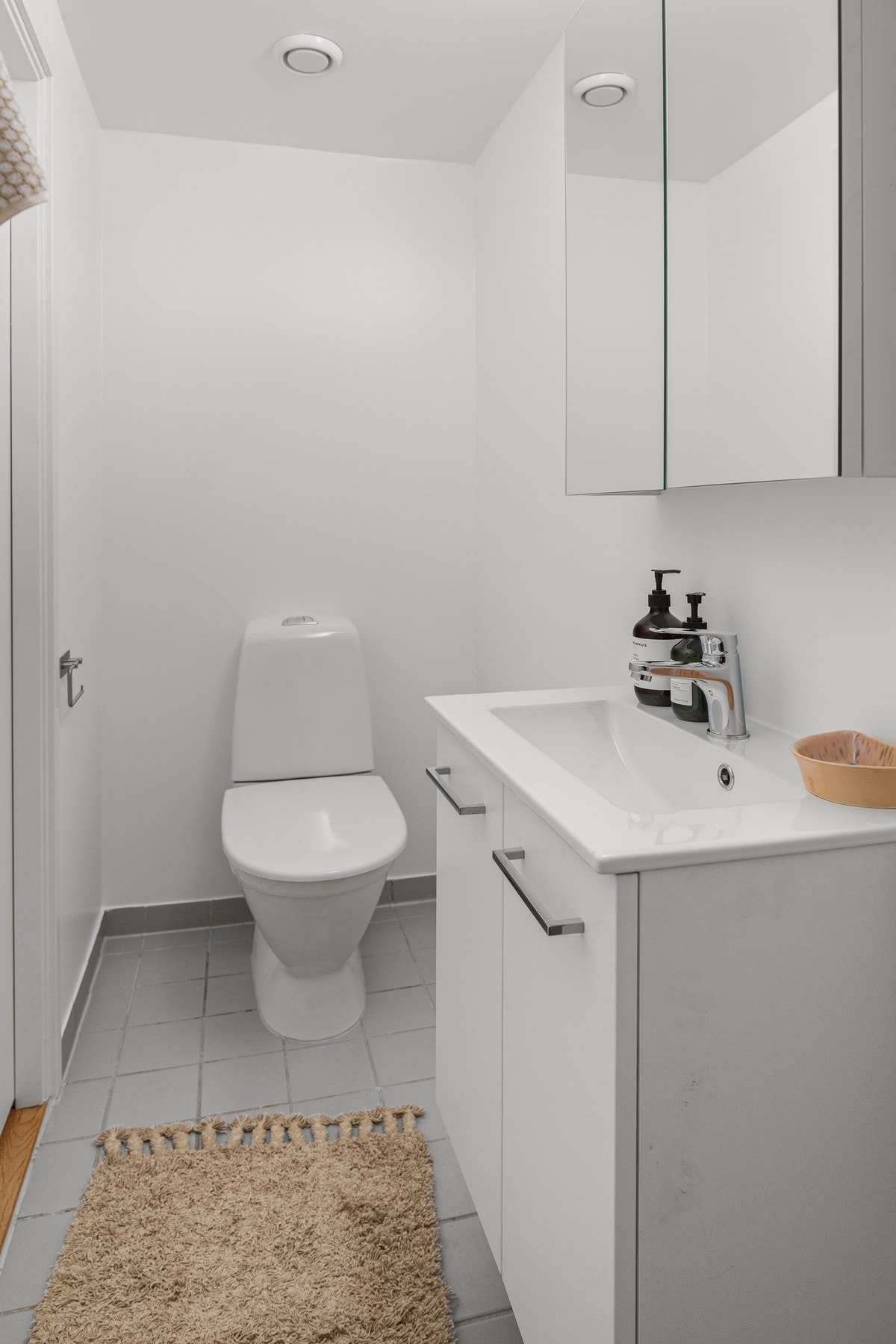 Badet inneholder dusjhjørne, servant med innredning, speil og toalett. Galleribilde