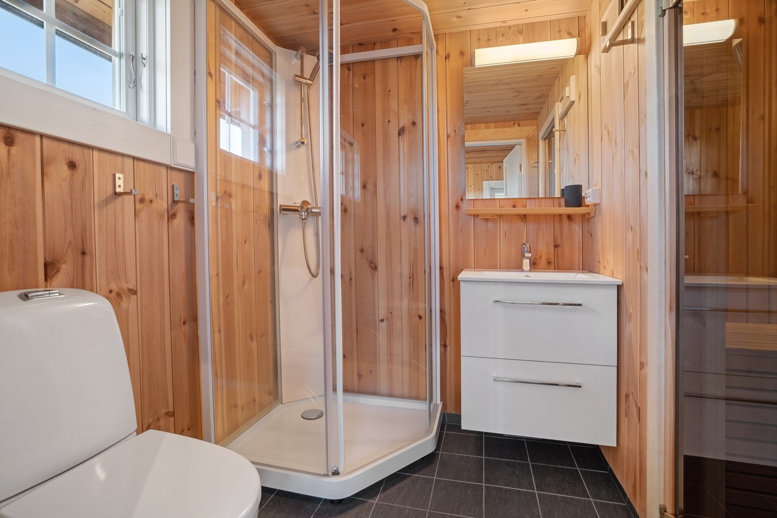 Bad med wc, dusjkabinett og baderomsinnredning. Galleribilde