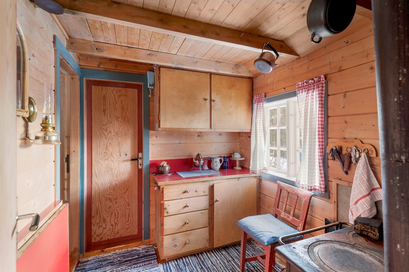 Kjøkkenet har montert en enkel innredning av benkeskap og overskap, med laminert benkeplate Galleribilde