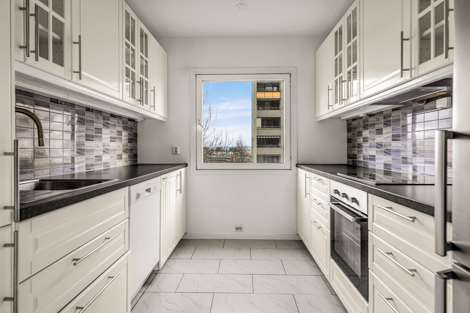 Kjøkkeninnredningen ble oppgradert rundt 2016 og har profilerte fronter samt overskap med innfelte glassfelt og benkeplater av laminat gir et klassisk og tidløst uttrykk. Galleribilde