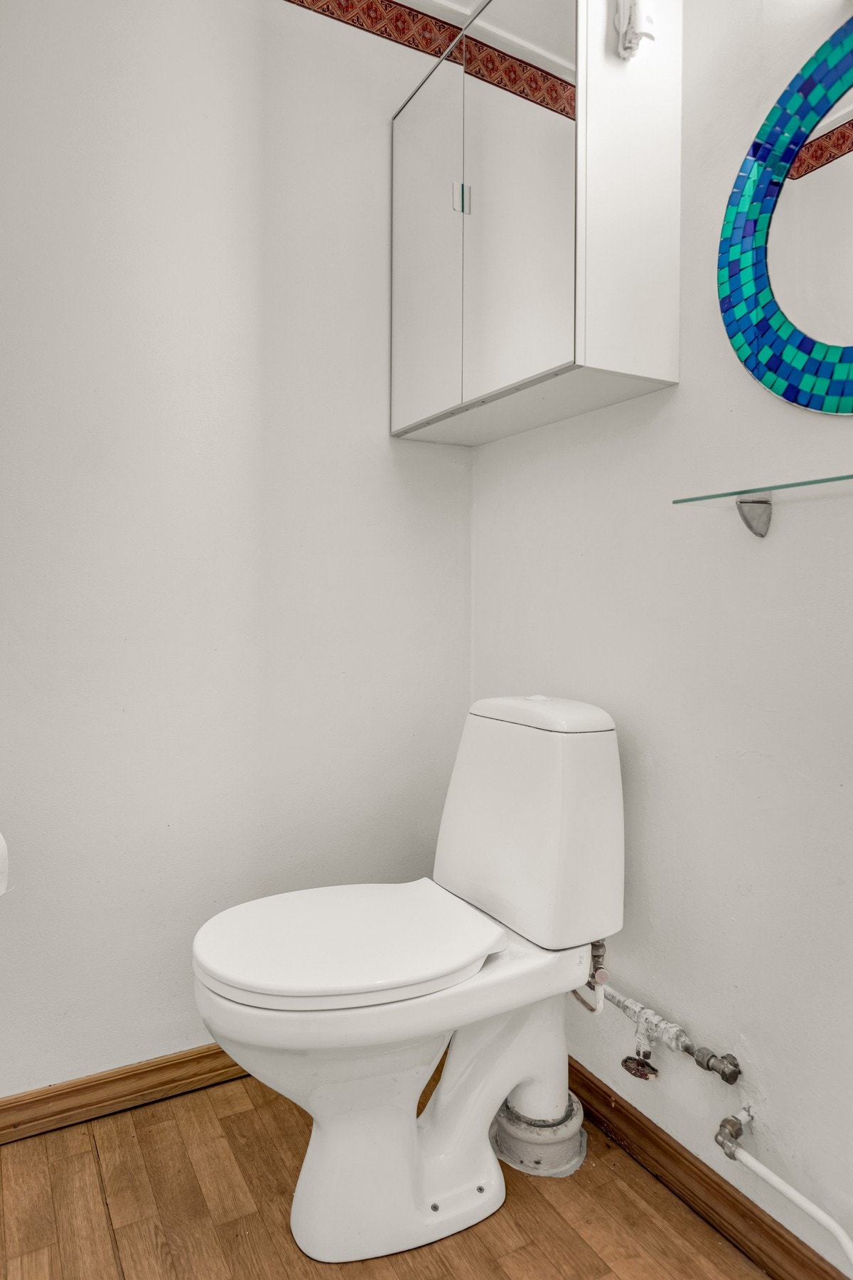 Praktisk separat toalettrom. Innredet med gulvstående toalett, speil og belysning på vegg. Galleribilde